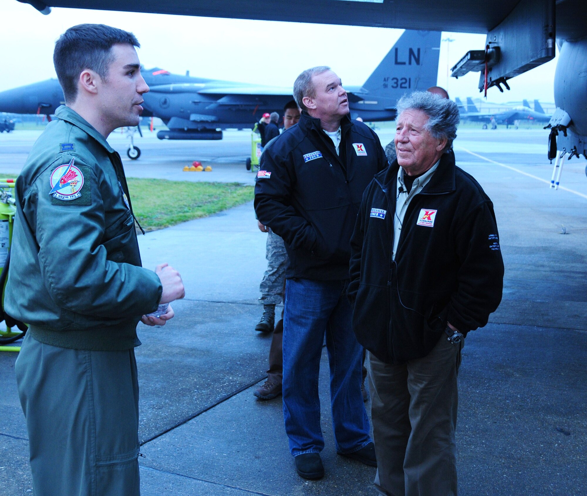 ROYAL AIR FORCE LAKENHEATH, England -- Capt. Craig Nordgren, 492nd Fighter Squadron pilot, shows an F-15 to Mario Andretti and Al Unser Jr. (middle), during the Indy 500 Centennial Tour sponsored by Armed Forces Entertainment. The drivers visited the base as part of a tour to show their appreciation of servicemembers and their families.  (U.S. Air Force photo/Staff Sgt. Connor Estes)
