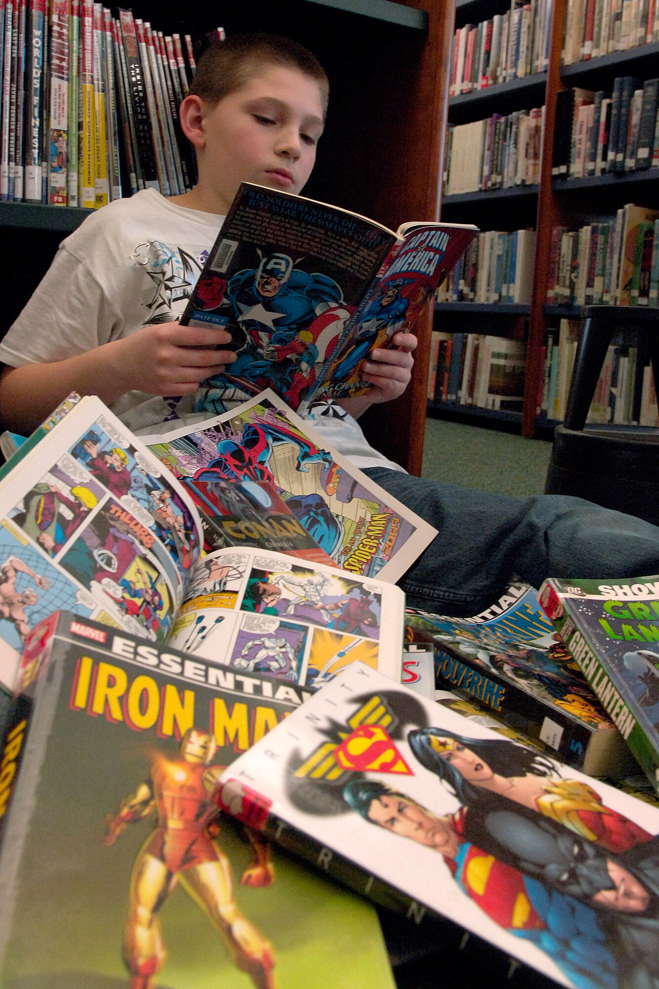 Zachary Gregoire reads graphic novels at the base library Jan. 14, 2011. These are one of the many new formats available for check out. The library also has teen novels, childrens books and best-sellers. (U.S. Air Force photo illustration/Senior Airman Natasha E. Stannard)