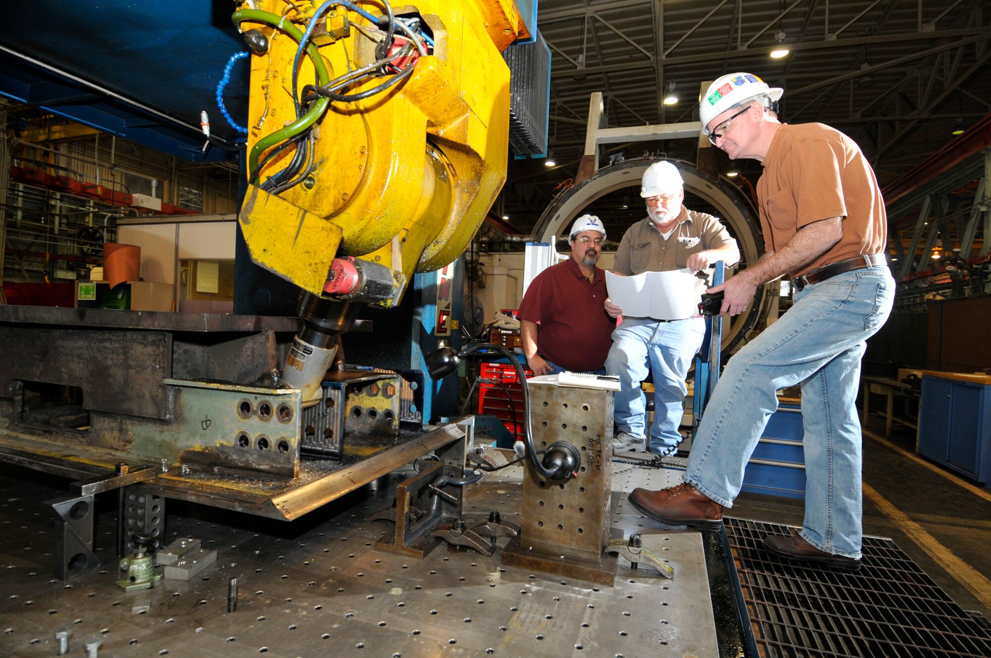 Russell Arbuckle uses the AEDC Model Shop’s large gantry mill to correct distortion caused by welding on a diffuser plate from the Von Kármán Gas Dynamic Facility Wind Tunnel A as Joel Gregory and Larry Stanford look on. (Photo by Rick Goodfriend)