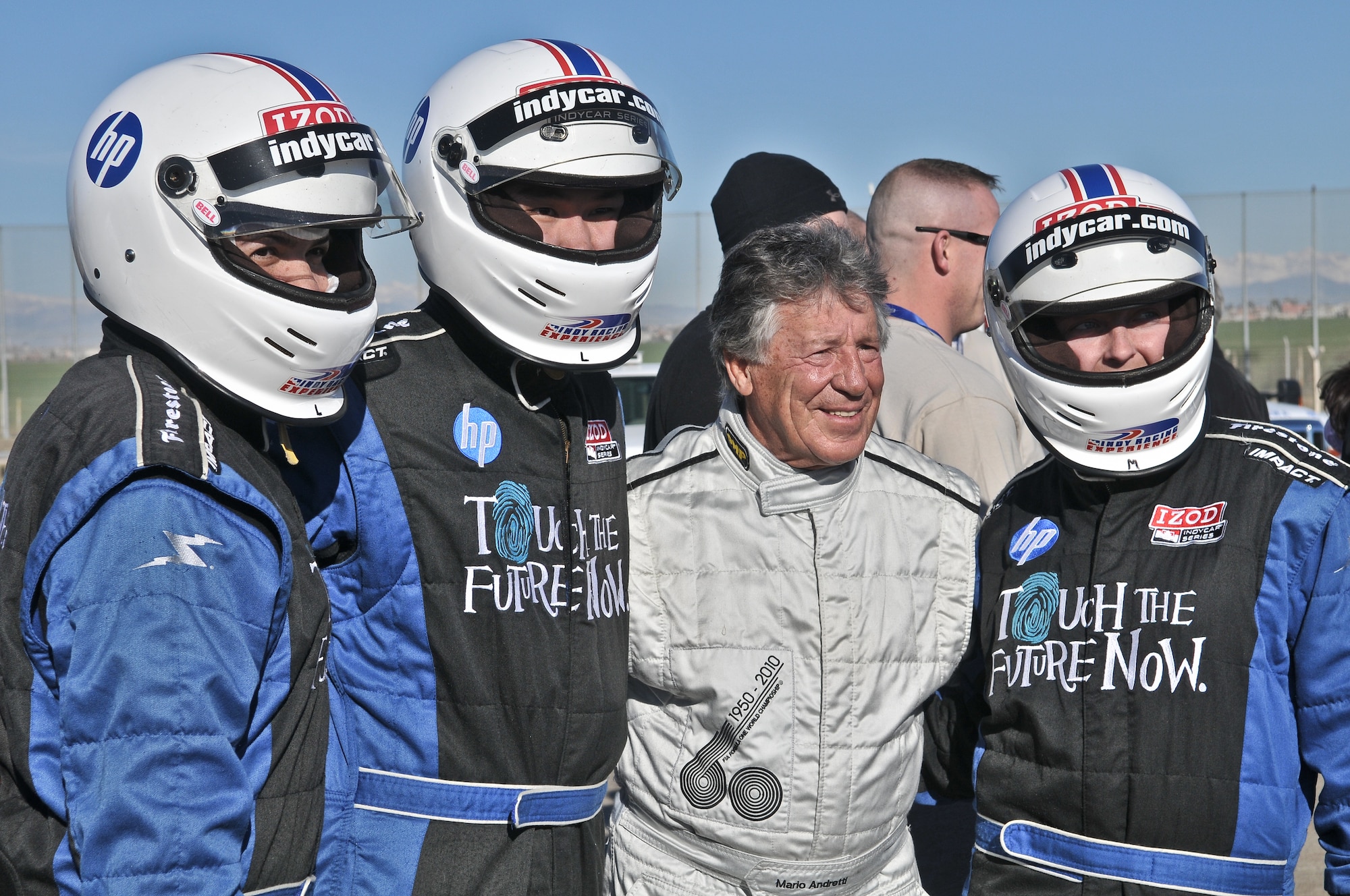 Four-time Indianapolis 500 race winner Mario Andretti takes a moment between demo rides to sign autographs and take photos during the Indy 500 Centennial Tour Jan.19, at Incirlik Air Base, Turkey. More than 30 individuals were chosen to ride in the Indy 500 racecar. The majority of the winners were from a drawing and the rest were chosen by their first sergeants. The Indy 500 Centennial Tour, coordinated by Morale Entertainment Foundation and Armed Forces Entertainment, in conjunction with the IZOD Indy Car Series and the Indianapolis Motor Speedway, is a 10-day morale trip to Europe and the Middle East with the goal of boosting the morale of more than 10,000  servicemembers. The team, which includes Indianapolis 500 winners Mario Andretti, Johnny Rutherford and Al Unser Jr. plus Indy 500 veterans Sarah Fisher, Davey Hamilton, Larry Foyt and Firestone Indy Lights race winner Martin Plowman, spoke with the winners and signed autographs during the visit. (U.S. Air Force photo by Staff Sergeant Alexandre Montes/Released)