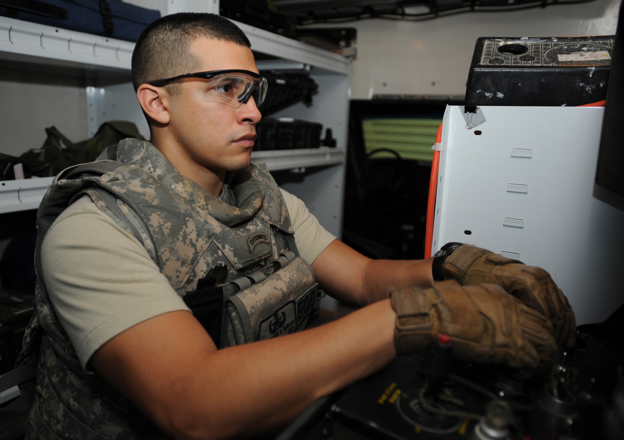 Senior Airman Christopher Barajas, 380th Expeditionary Civil Engineer Squadron, concentrates on removing a simulated explosive Jan. 20, 2010, at the Explosive Ordinance Disposal shop. It usually takes about 30 minutes to three hours to completely remove and defuse an explosive, depending on the type. (U.S. Air Force photo by Senior Airman Maynelinne De La Cruz)(Released)