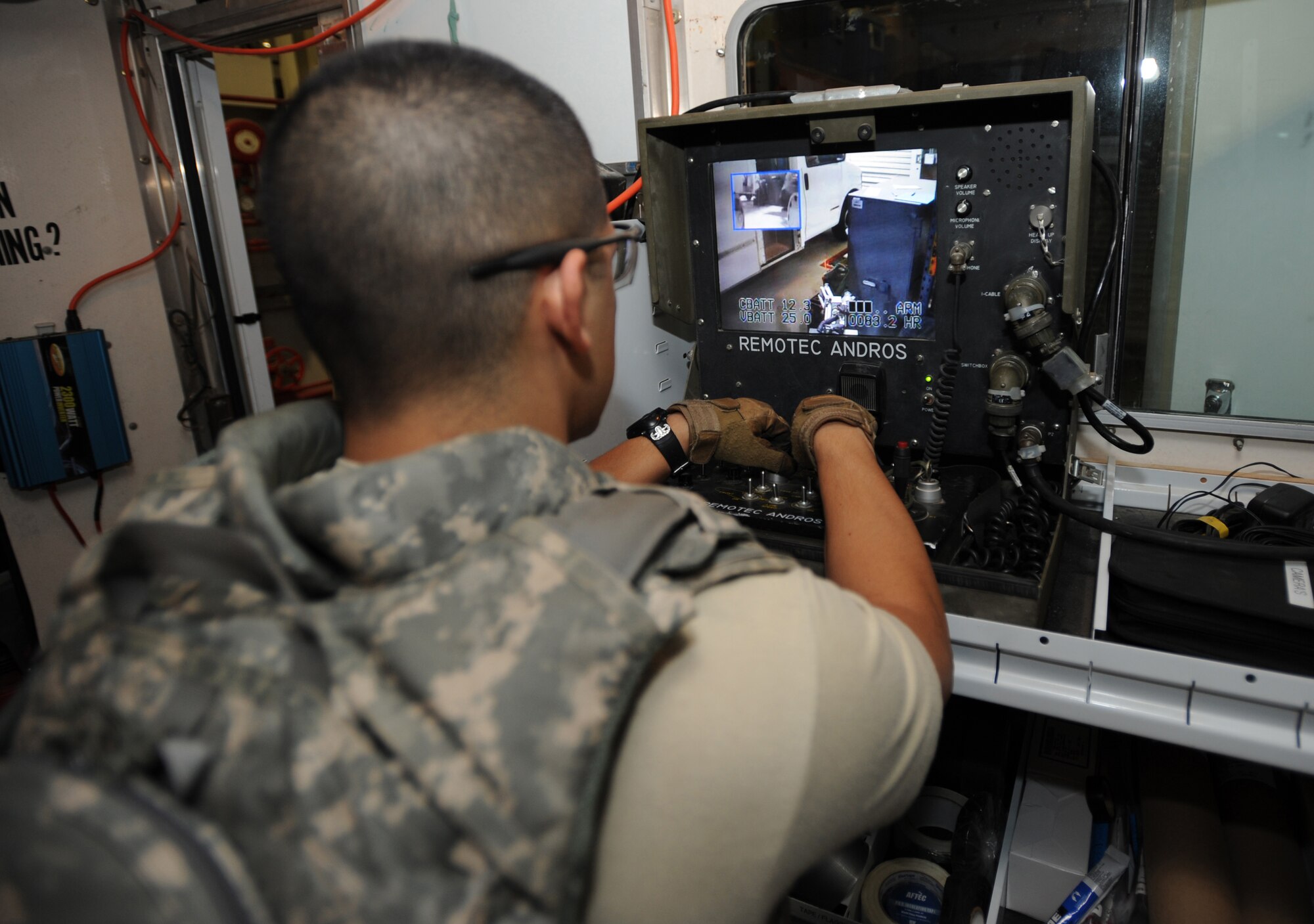 Senior Airman Christopher Barajas, 380th Expeditionary Civil Engineer Squadron, controls the F6A robot from the Operator's Control Unit truck Jan. 20, 2010, at the Explosive Ordinance Disposal shop. It usually takes about 30 minutes to three hours to completely remove and defuse an explosive, depending on the type. (U.S. Air Force photo by Senior Airman Maynelinne De La Cruz)(Released)
