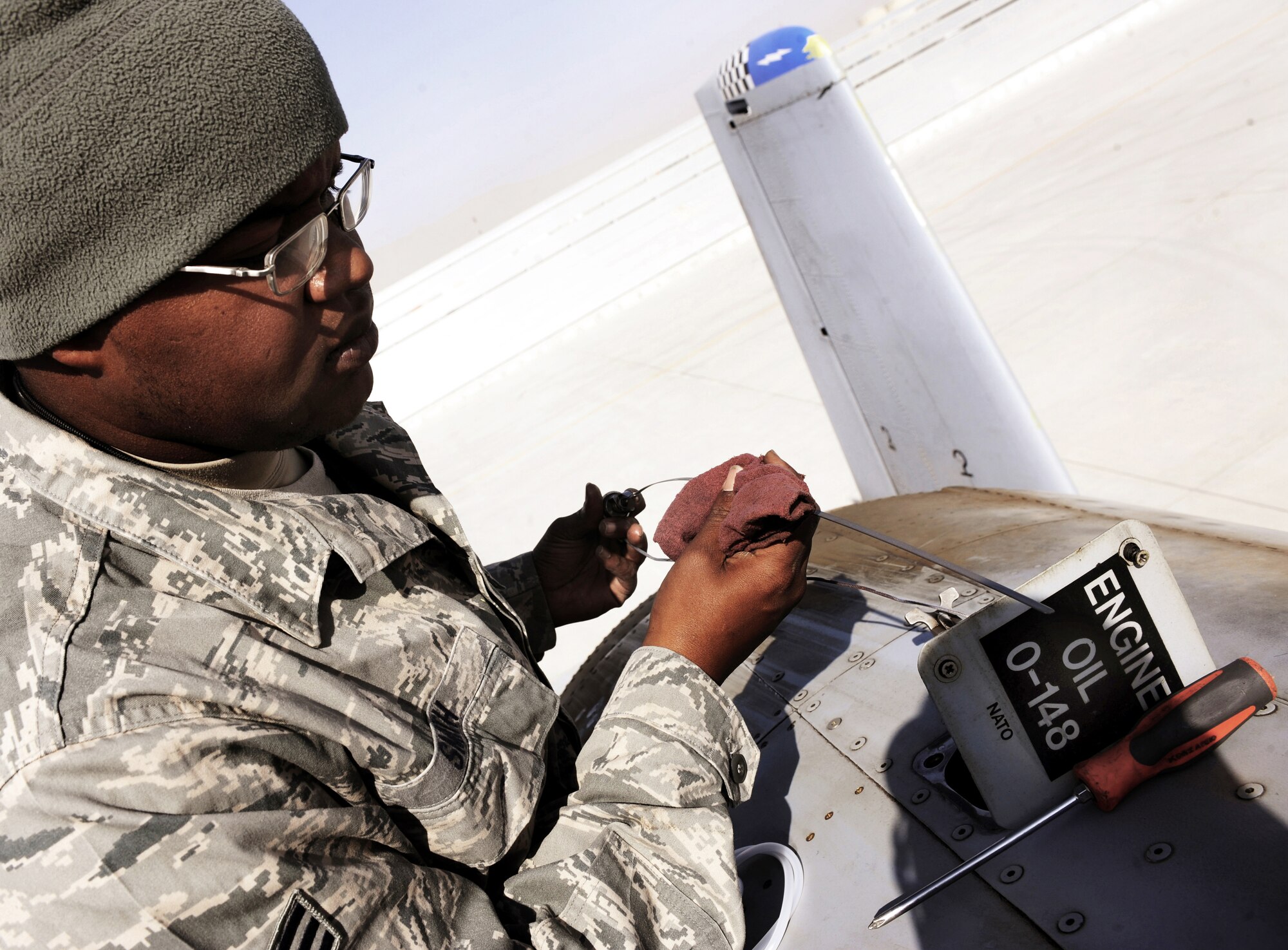 Senior Airman Christopher Smith checks the dipstick of an A-10C Thunderbolt II, Jan. 11, 2011, at Kandahar Airfield, Afghanistan. The 75th Expeditionary Fighter Squadron recently moved their assets to the other side of the flightline, marking the first of many moves toward consolidating the wing?s missions. Airman Smith is a crew chief assigned to the 451st Expeditionary Aircraft Maintenance Squadron. (U.S. Air Force photo/Senior Airman Willard E. Grande II)