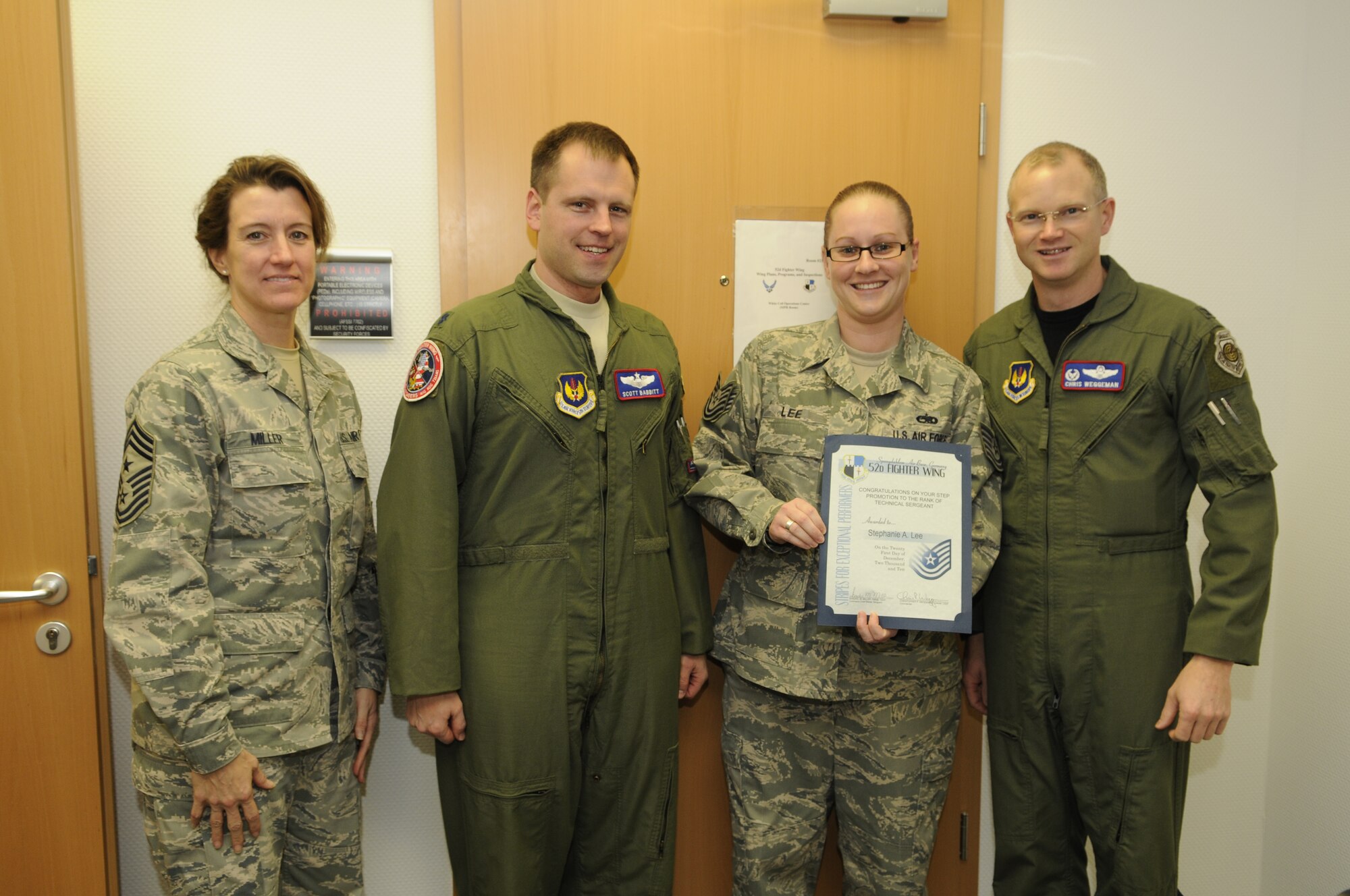 SPANGDAHLEM AIR BASE, Germany – Stephanie Lee, 52nd Fighter Wing Plans and Inspections, stands with Chief Master Sgt. Sandra Miller, 52nd FW command chief, Lt. Col. Scott Babbit and Col. Christopher Weggeman, 52nd FW commander, immediately following her selection for a Stripes for Exceptional Performers promotion to technical sergeant Dec. 21. (U.S. Air Force/Staff Sgt. Benjamin Wilson)