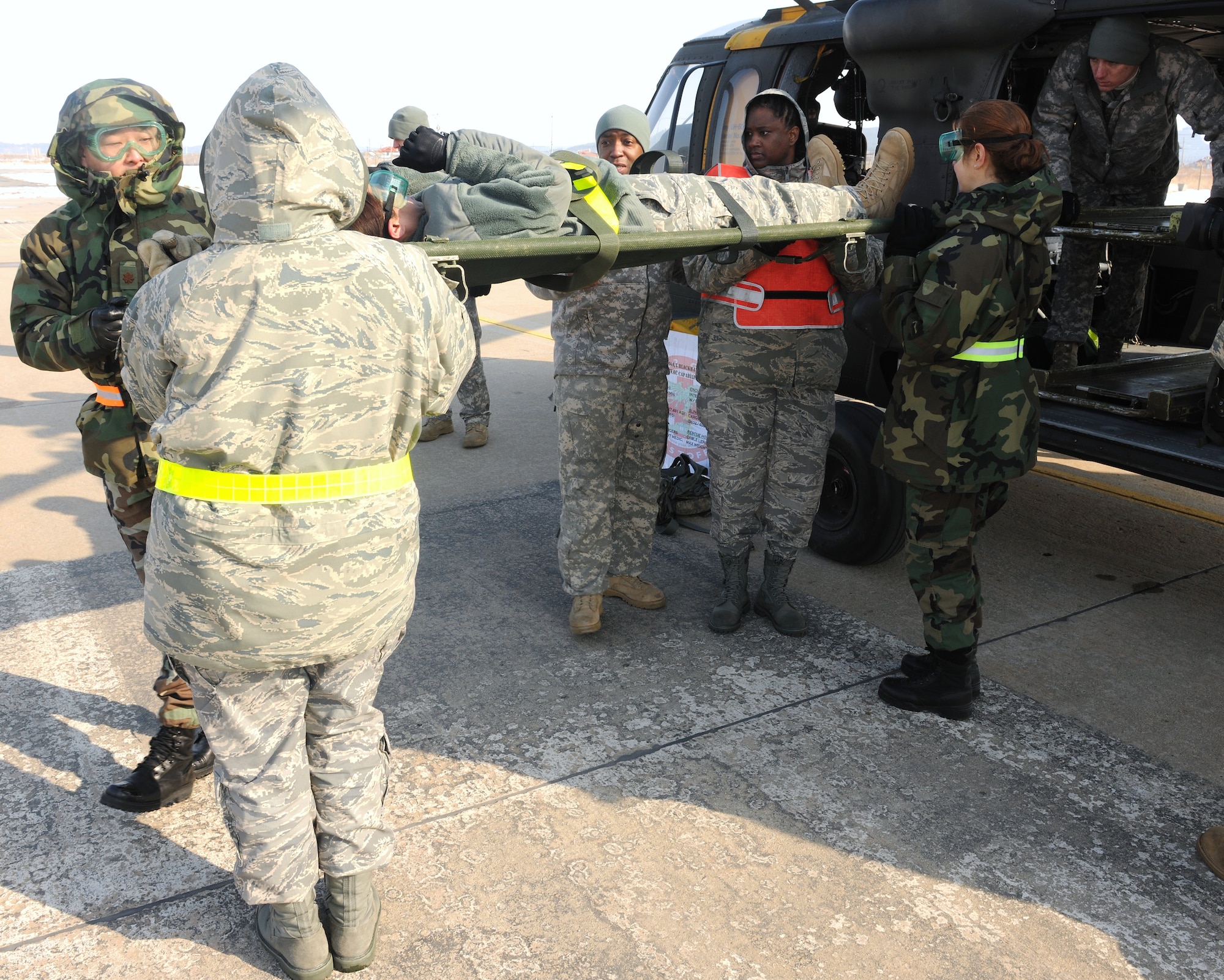 KUNSAN AIR BASE, Republic of Korea -- Members from the 8th Medical Group load a litter onto a UH-60 Black Hawk as Army Staff Sgt. Reginald Jones, Black Hawk flight medic, observes during medical evacuation training here Jan. 19. A Black Hawk team from Camp Humphreys visited the Wolf Pack to familiarize the medics with the medevac concept. (U.S. Air Force photo/Senior Airman Ciara Wymbs)