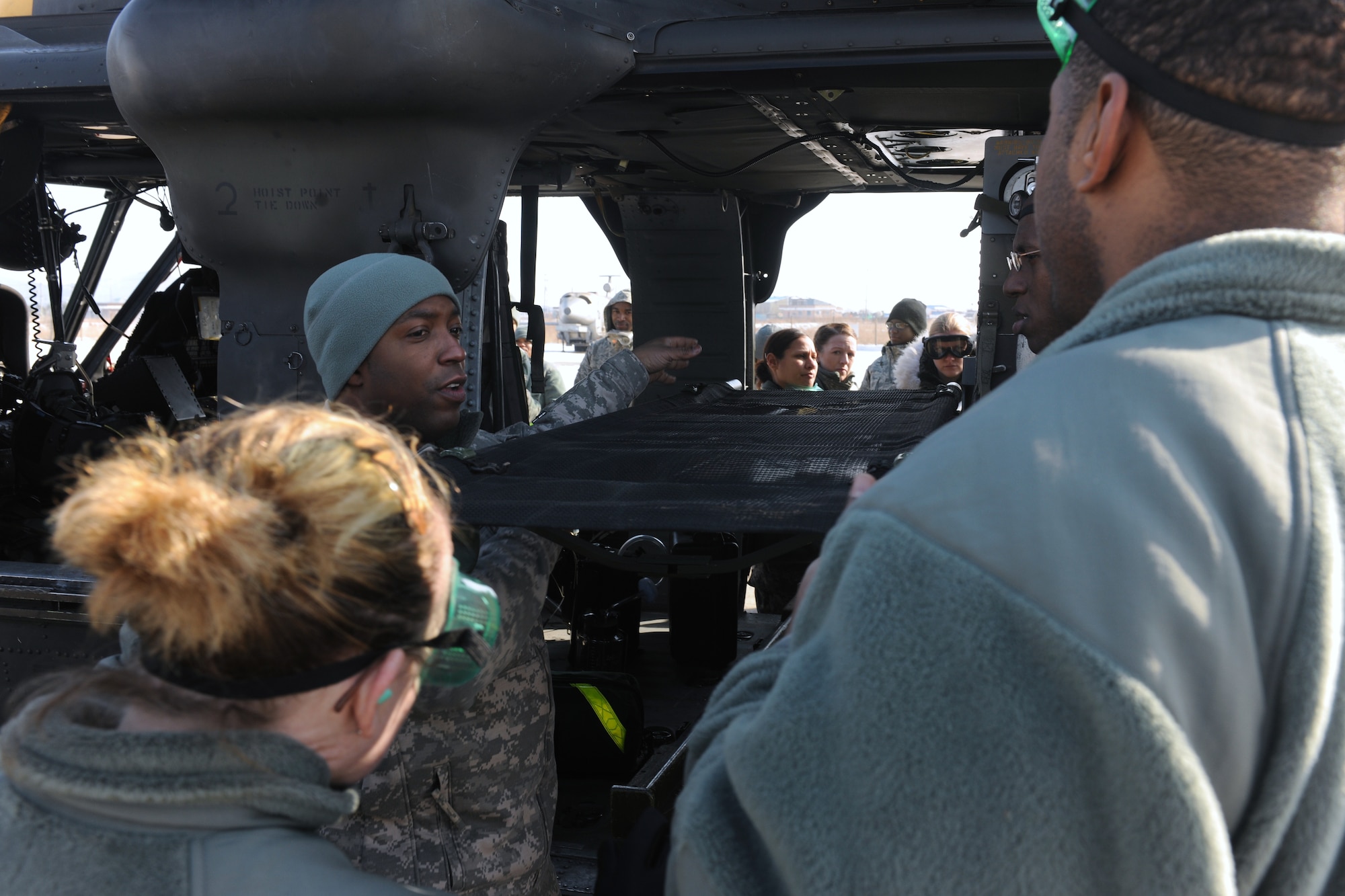 KUNSAN AIR BASE, Republic of Korea -- Members from the 8th Medical Group watch as Army Staff Sgt. Reginald Jones, UH-60 Black Hawk flight medic, demonstrates loading a litter during medical evacuation training here Jan. 19. A Black Hawk team from Camp Humphreys visited the Wolf Pack to familiarize the medics with the medevac concept. (U.S. Air Force photo/Senior Airman Ciara Wymbs)