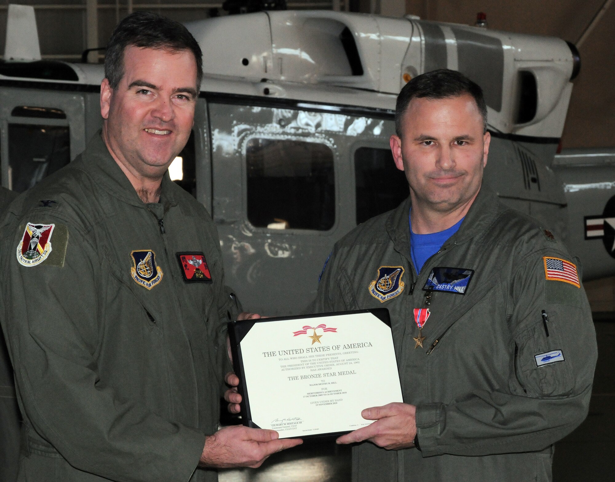 YOKOTA AIR BASE, Japan -- Col. Mark Hering, 374th Operations Group commander, presents Maj. Destry Hill, 374th OG assistant director of operations, with a certificate for his Bronze Star during a ceremony, here Jan. 14. The Bronze Star Medal is awarded to individuals for acts of heroism or meritorious achievement in ground combat. (U.S. Air Force photo/Airman 1st Class Katrina R. Menchaca)