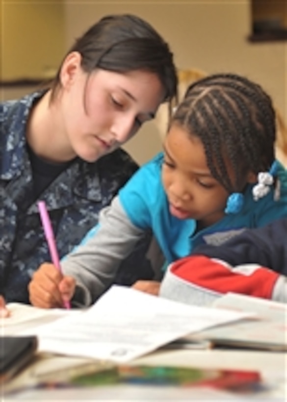 Airman Ashley Henderson, assigned to the aircraft carrier USS Theodore Roosevelt (CVN 71), writes notes of encouragement in books with first-grader Isabella Wyatt in Norfolk, Va., on Jan. 17, 2011.  Sailors assigned to the Theodore Roosevelt volunteered as mentors in the Volunteer Hampton Roads 2011 Martin Luther King Jr. Day of Service.  The Theodore Roosevelt is undergoing a multi-year refueling complex overhaul at Northrop Grumman Newport News Shipbuilding.  