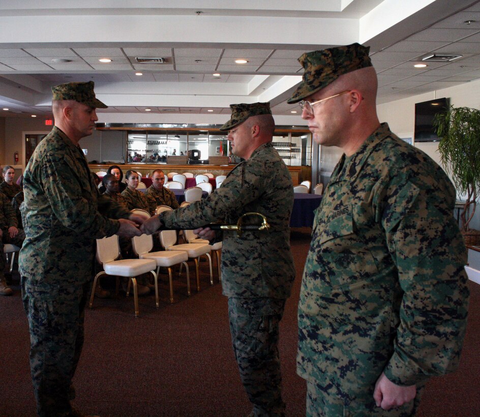Sergeant Maj. Benjamin Pangborn (left) takes over as sergeant major of Wounded Warrior Battalion East in a post and relief ceremony with Sgt. Maj. Joel Collins (front, right) here Jan. 21, 2011.  Lt. Col. Nicholas Davis, the battalion commander, presides over the ceremonial handing off of the staff non-commissioned officer sword.  Pangborn comes to Wounded Warriors from Okinawa, Japan, where he served as sergeant major of Headquarters and Headquarters Squadron, Marine Corps Air Station Futenma, for nearly three years.  Collins will go on to be the battalion sergeant major for 1st Battalion, 2nd Marine Regiment, 2nd Marine Division at Camp Lejeune.