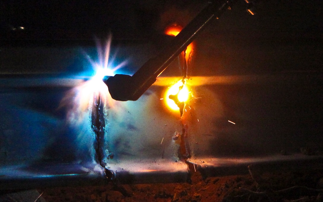 Lance Cpl. Jesse G. Mudd, 20, a welder with Combat Logistics Battalion 3, 1st Marine Logistics Group (Forward), cuts metallic siding for a bridge in Durzay, Afghanistan, Jan. 21. Mudd, a native of Smith Center, Kansas, is the only metal worker for CLB-3's Engineer Company. While deployed to Afghanistan, Mudd has played a key role in several military construction projects for coalition units as well as civil development projects for the Afghan community.