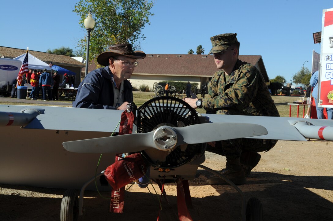 Sgt. Christopher Herr, right, Marine Unmanned Aerial Vehicle Squadron 4 systems operations instructor, explains the RQ-7B Shadow unmanned aerial vehicle to Curtis Hammond, a native of Prince Albert, Saskatchewan, Canada during the first Spirit of Yuma Military Appreciation festival at the Yuma Quartermaster Depot, Jan. 21, 2011. "It's an incredible machine," said Hammond. "We're so happy to live next to such a wonderful country and to be able to see something like this on our first visit to Yuma."