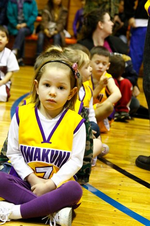 Maya Walters, number 7 for 5- to 6-year-old division Team 2, sits with the rest of her team before they are introduced at the opening ceremonies here Jan. 22. Walters and her team mates were excited to start playing their favorite sport.