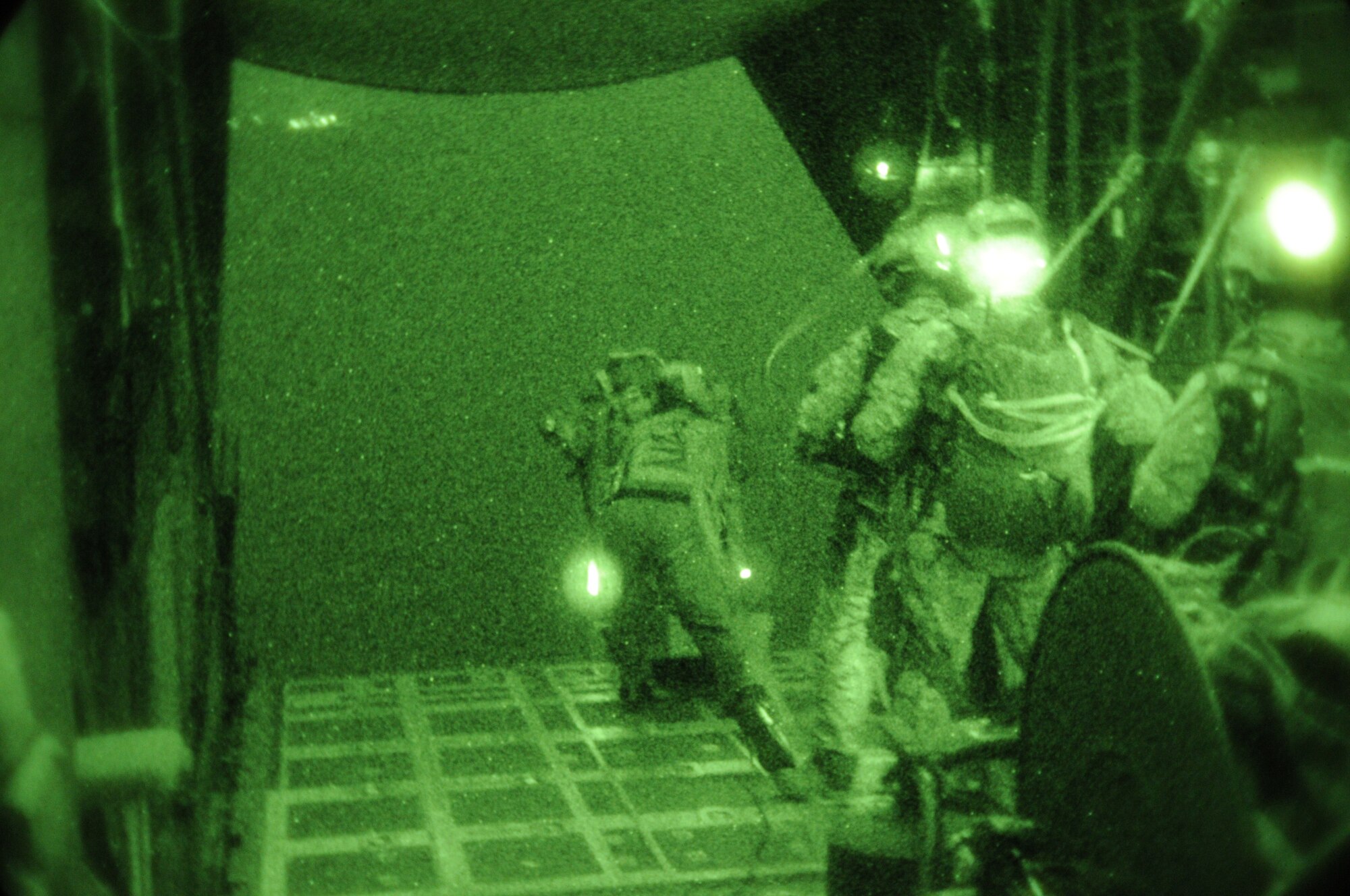 OVER IE SHIMA AIRFIELD, Japan -- Tech. Sgt. James Kosnosky, a loadmaster with the 1st Special Operations Squadron, pushes an assault bike out of a MC-130H Combat Talon II as combat controllers from the 320th Special Tactics Squadron, look on Jan. 20 as part of Beverly High 11-02, a local operational readiness exercise. The scenario called for the combat controllers to parachute into "hostile" territory, secure the airfield and then control the aircraft while it landed at the airfield. Combat Controllers are trained special operations forces and certified FAA air traffic controllers. Members of the 353rd Special Operations Group are participating in the exercise to hone their warfighting skills in preparation for a headquarters inspection next month. (U.S. Air Force photo by Tech. Sgt. Aaron Cram)