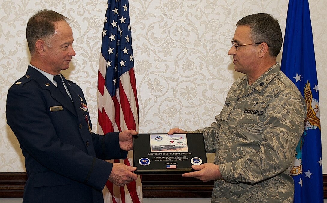 Lt. Col. Donald Weimer (left) accepts a plaque from Lt. Col. Wesley Kilmer, commander of the 932nd Aeromedical Evacuation Squadron following his official retirement from the Air Force Reserve.  Colonel Weimer is a career C-9C pilot who logged more than 12,000 flying hours.   Colonel Weimer has been the 932nd Airlift Wing, Chief of Flight Safety since 1990.  (U.S. Air Force photo/Tech. Sgt. Christopher Parr)  