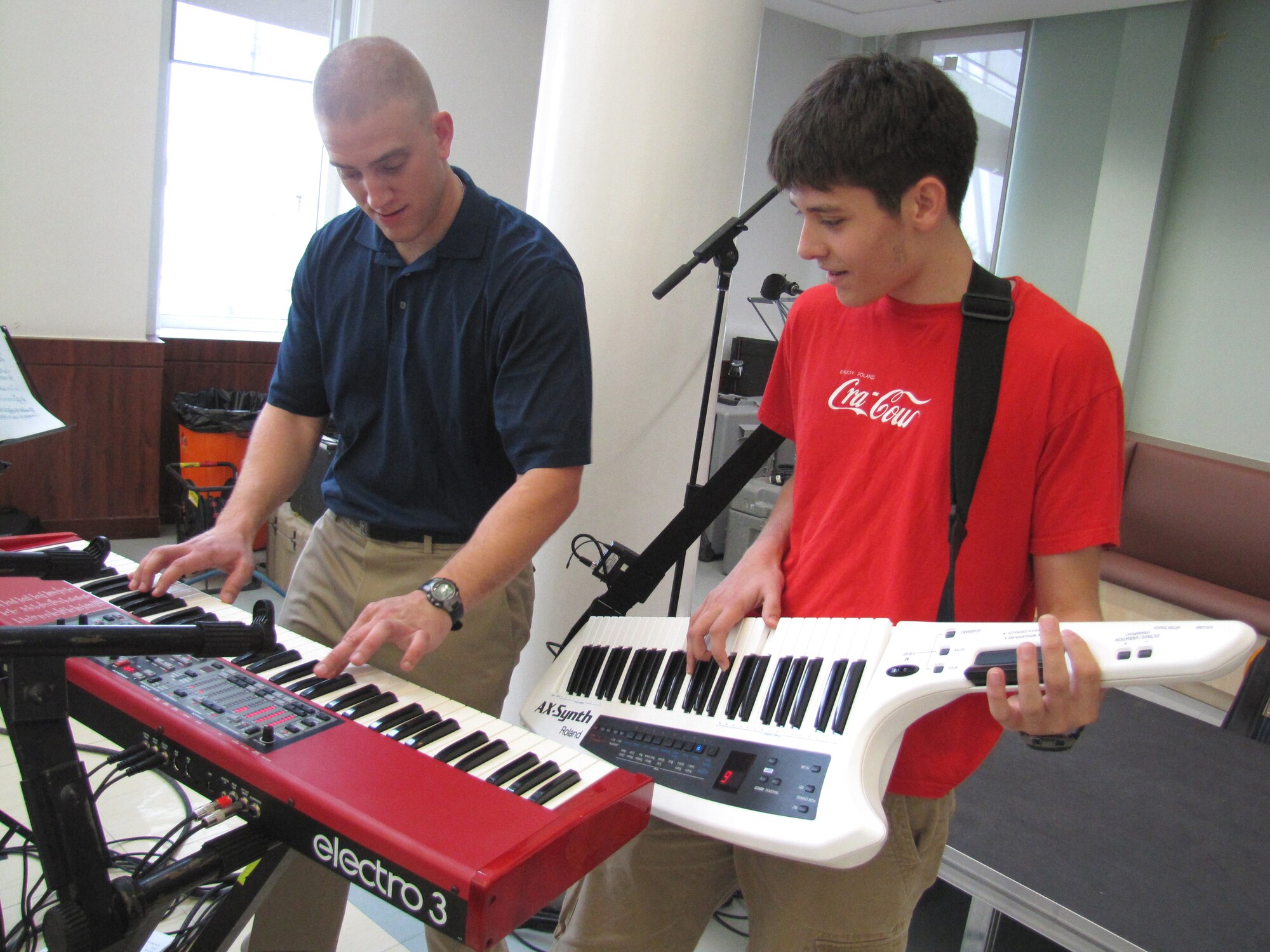 A music student at an American secondary school at an undisclosed location in Southwest Asia gets the opportunity to play "Free Bird" by Lynyrd Skynyrd with pianist, Senior Airman Adam Braatz, after a performance by Starlifter, the U.S. Air Forces Central Band, Jan. 19. (U.S. Air Force photo by Staff Sgt. Angelique N. Smythe) 
