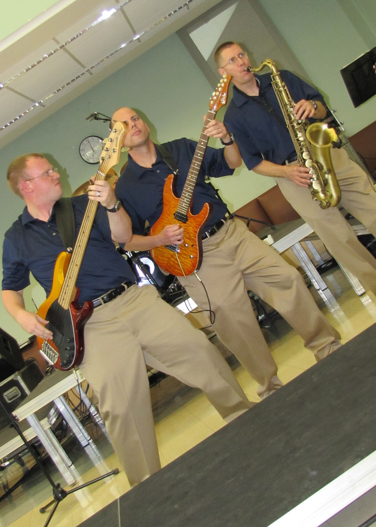Bass player, Senior Airman Brian Plank, guitar player, Master Sgt. Jerry Kelley, and saxophonist, Tech. Sgt. Dwight West, play during a performance by Starlifter, the U.S. Air Forces Central Band, for approximately 600 students in an American secondary school at an undisclosed location in Southwest Asia, Jan. 19. (U.S. Air Force photo by Staff Sgt. Angelique N. Smythe)
