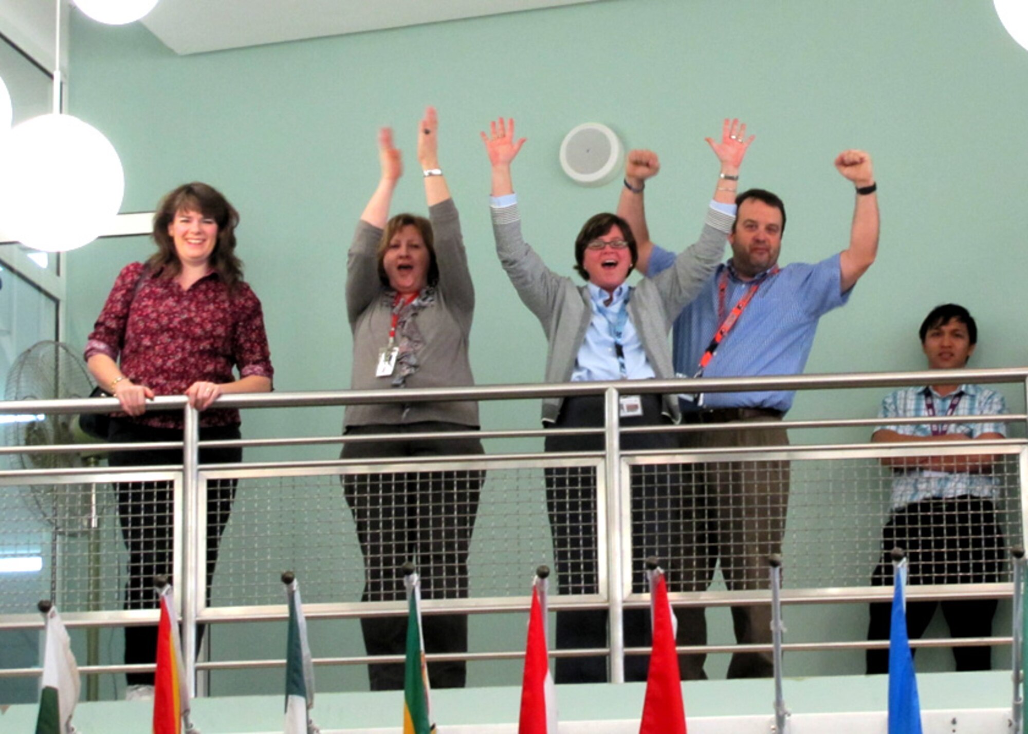 Faculty members on the second floor balcony cheer during a performance of 80's medleys by the U.S. Air Forces Central Band, Starlifter. Approximately 600 students in an American secondary school at an undisclosed location in Southwest Asia gathered in their cafeteria for a live performance by the band, Jan. 19. (U.S. Air Forces photo by Staff Sgt. Angelique N. Smythe)
