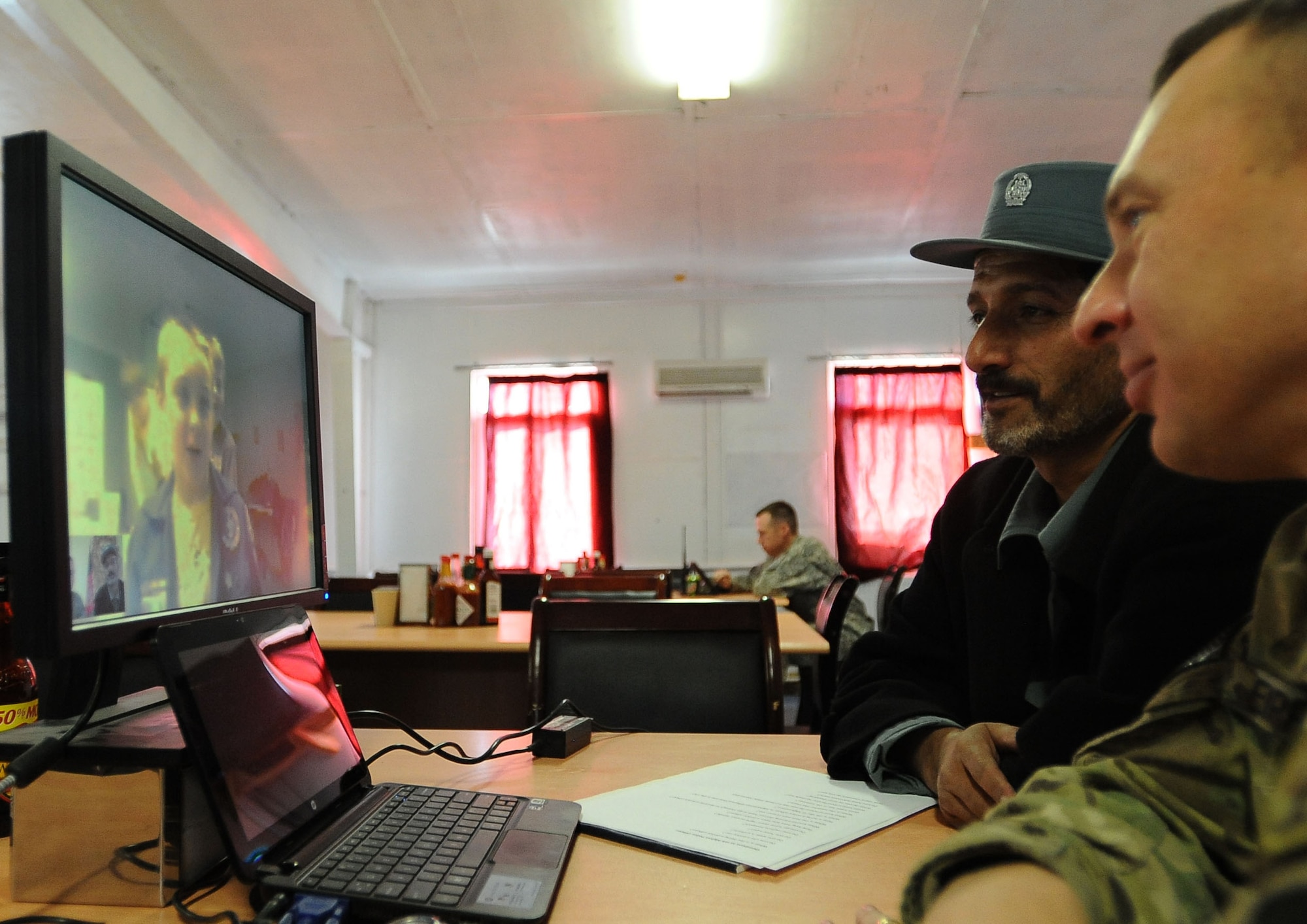 Capt. Sefat Mire, Afghan National Police training officer for Rokha District (left), and U.S. Army Master Sgt. Todd Eipperle, senior non-commissioned officer in charge of Task Force Red Bulls Embedded Training Team in Panjshir, and Marshalltown, Iowa, native, speak with Cub Scouts via Skype here Jan. 22. Cub Scouts from Pack 182, located in Ankeny, Iowa, were able to ask the ANP officer several questions about his life in Afghanistan. (Photo by U.S. Air Force Senior Airman Amber Ashcraft)