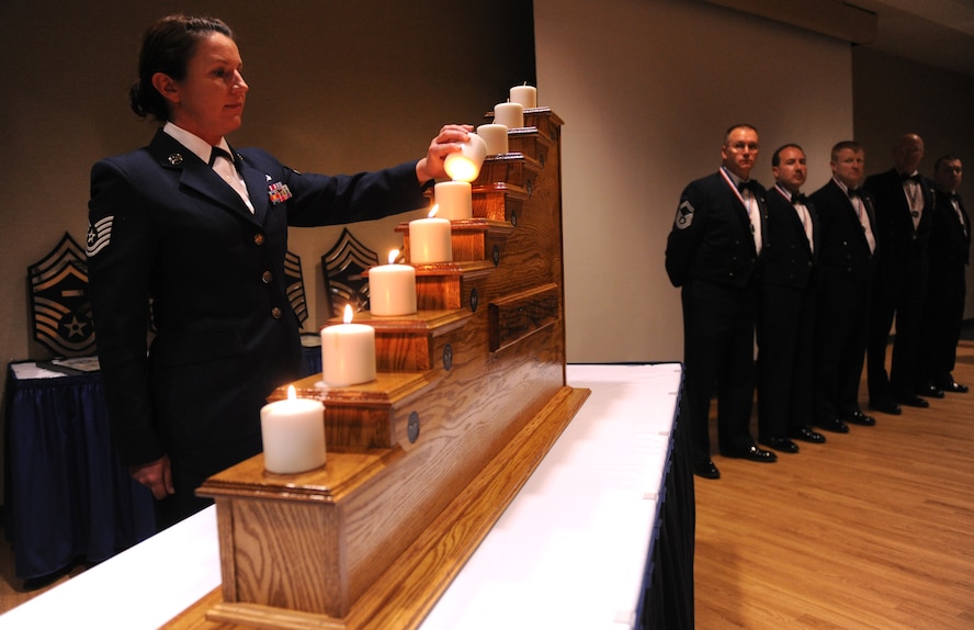 MOODY AIR FORCE BASE, Ga.-- Tech. Sgt. Petina Hunt, 23rd Wing protocol NCO in charge, lights a candle during the Chief Recognition Ceremony Jan. 22. Each candle represents a rank from airman basic to chief master sergeant and was lit to demonstrate the journey that the six senior master sergeants had to take before being promoted to chief master sergeant. (U.S. Air Force photo/Airman 1st Class Benjamin Wiseman)(RELEASED)