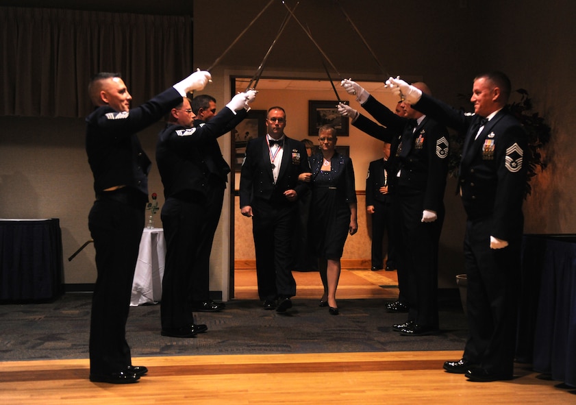 MOODY AIR FORCE BASE, Ga.-- A saber detail raises their swords as Senior Master Sgt. Dennis James, 23rd Civil Engineer Squadron chief enlisted manager, and his wife, Tammy, make their entrance during the Chief Recognition Ceremony Jan. 22. Each chief select was brought in separately to be recognized for their accomplishment of being promoted to the rank of chief master sergeant. (U.S. Air Force photo/Airman 1st Class Benjamin Wiseman)(RELEASED)