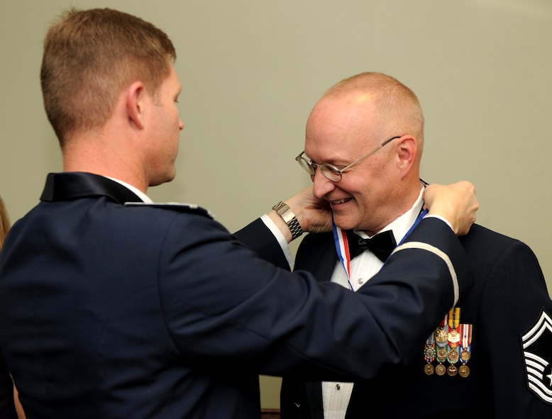 MOODY AIR FORCE BASE, Ga.-- Senior Master Sgt. Corey Christians, 23rd Equipment Maintenance Squadron munitions flight superintendent, receives a medallion from Col. Gary Henderson, 23rd Wing commander, during the Chief Recognition Ceremony Jan. 22. Each chief select was given a medallion and their spouse received a rose before dinner was served during the ceremony. (U.S. Air Force photo/Airman 1st Class Benjamin Wiseman)(RELEASED)