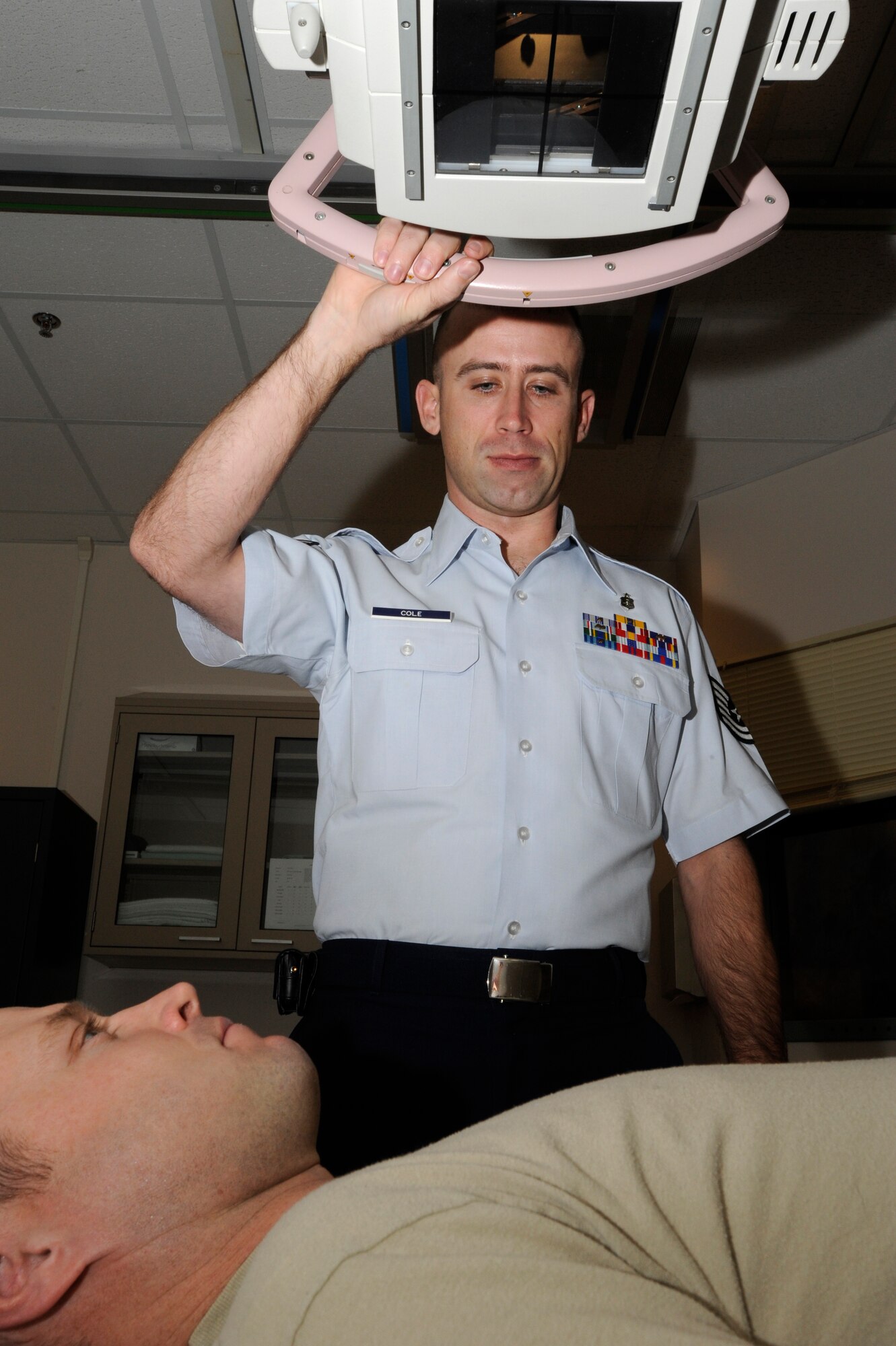 Tech. Sgt. Billy Cole, 22nd Medical Support Squadron Diagnostic Imaging assistant NCOIC demonstrates a radiographic exam, Jan. 24, 2011, McConnell Air Force Base, Kan. The images that the Cleveland, Tenn., native produces help physicians determine the source of patients’ worries. 