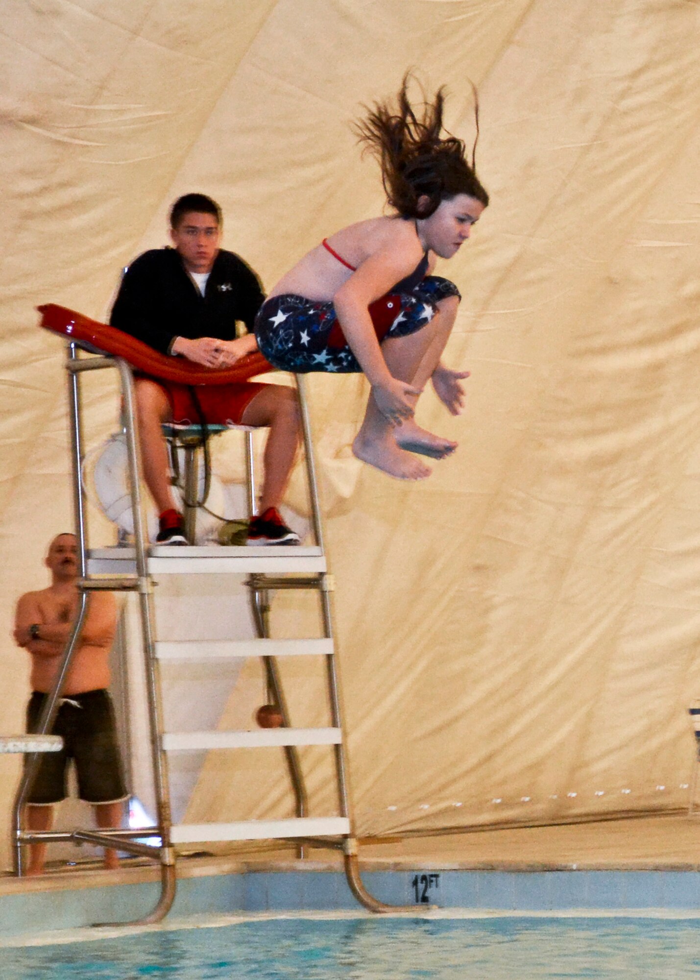 Genevieve Miller dives feet first in the Cannonball contest Jan. 24 at the Eglin East Gate pool. People enjoyed free music, food, and games like water basketball and volleyball during the winter pool party.  (U.S. Air Force Photo/Sachel Seabrook)

