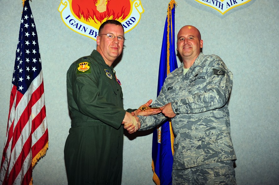 DYESS AIR FORCE BASE, Texas—Col. Lawrence M. Martin Jr., Air Mobility Command deputy A3, presents Staff Sgt. Cory Hartley, C-130J crew chief, 317th Airlift Group, the honorary key to the newest C-130J. “Even with all the new technology and improvements to the C-130J model, the key to mission success is the phenomenal capability we have from our well trained Airmen,” said Colonel Martin. (Air Force photo/ Airman First Class Courtney Moses)