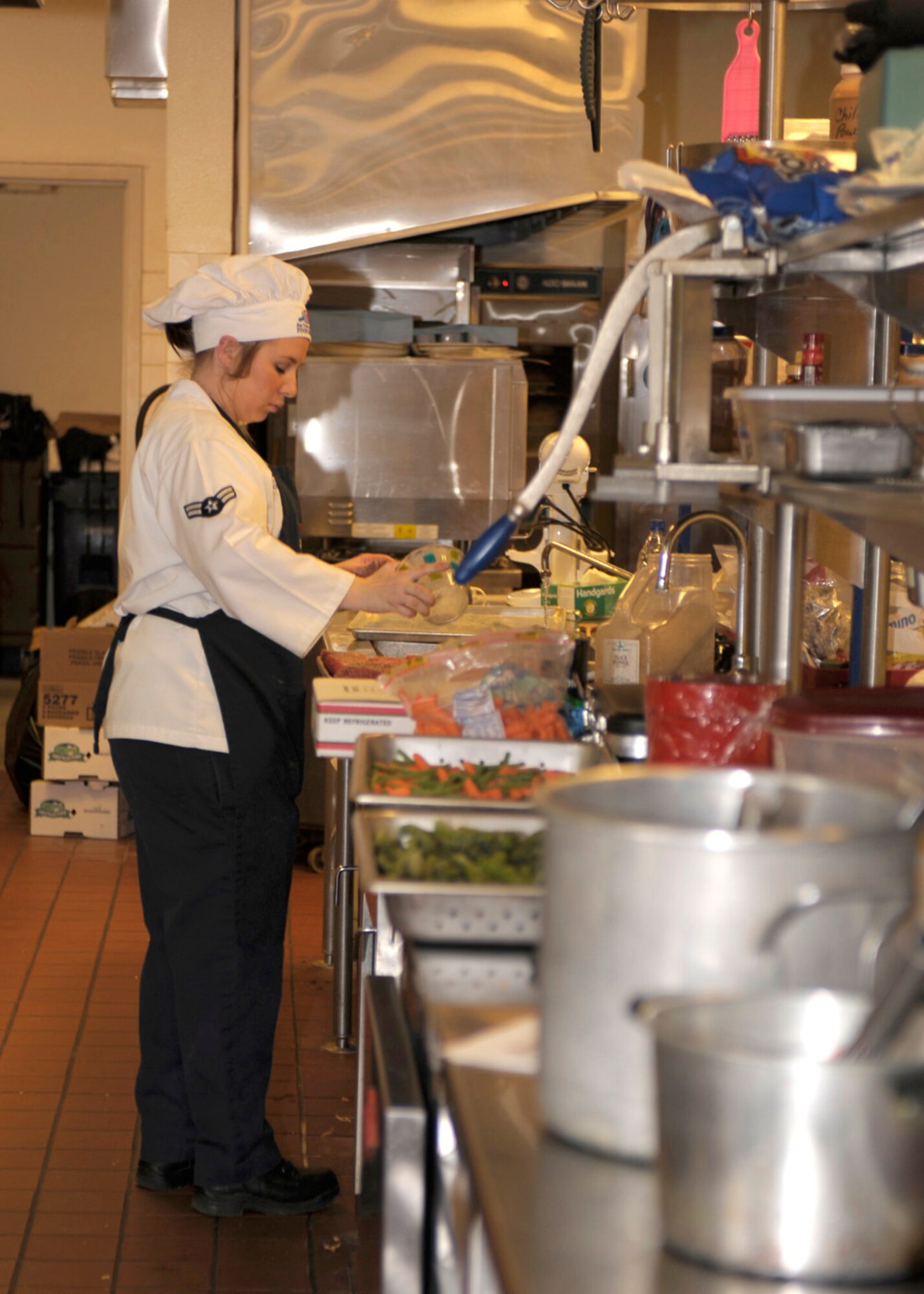 Airman 1st Class Miranda Burton, 27th Special Operations Force Support Squadron, prepares a course for a meal during the Iron Chef competition at The Landing Zone at Cannon Air Force Base, N.M., January 22. The competition to see which team was best was decided by diners who attended the event. The Landing Zone team was selected over the Pecos Trail Dining Facility. (U.S. Air Force photo by Airman Ericka Engblom)