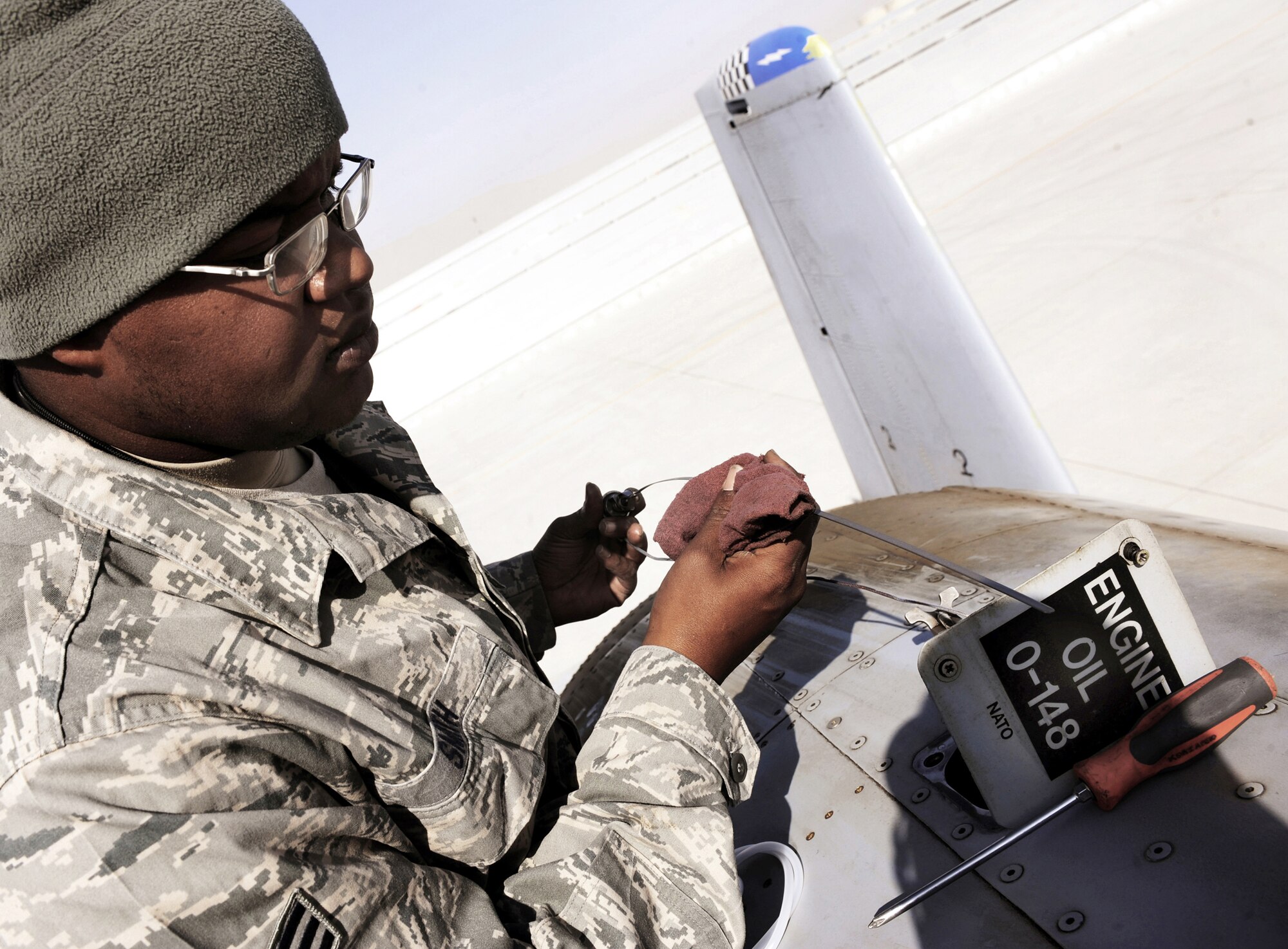 Senior Airman Christopher Smith checks the dipstick of an A-10C Thunderbolt II, Jan. 11, 2011, at Kandahar Airfield, Afghanistan. The 75th Expeditionary Fighter Squadron recently moved their assets to the other side of the flightline, marking the first of many moves toward consolidating the wing's missions. Airman Smith is a crew chief assigned to the 451st Expeditionary Aircraft Maintenance Squadron. (U.S. Air Force photo/Senior Airman Willard E. Grande II) 