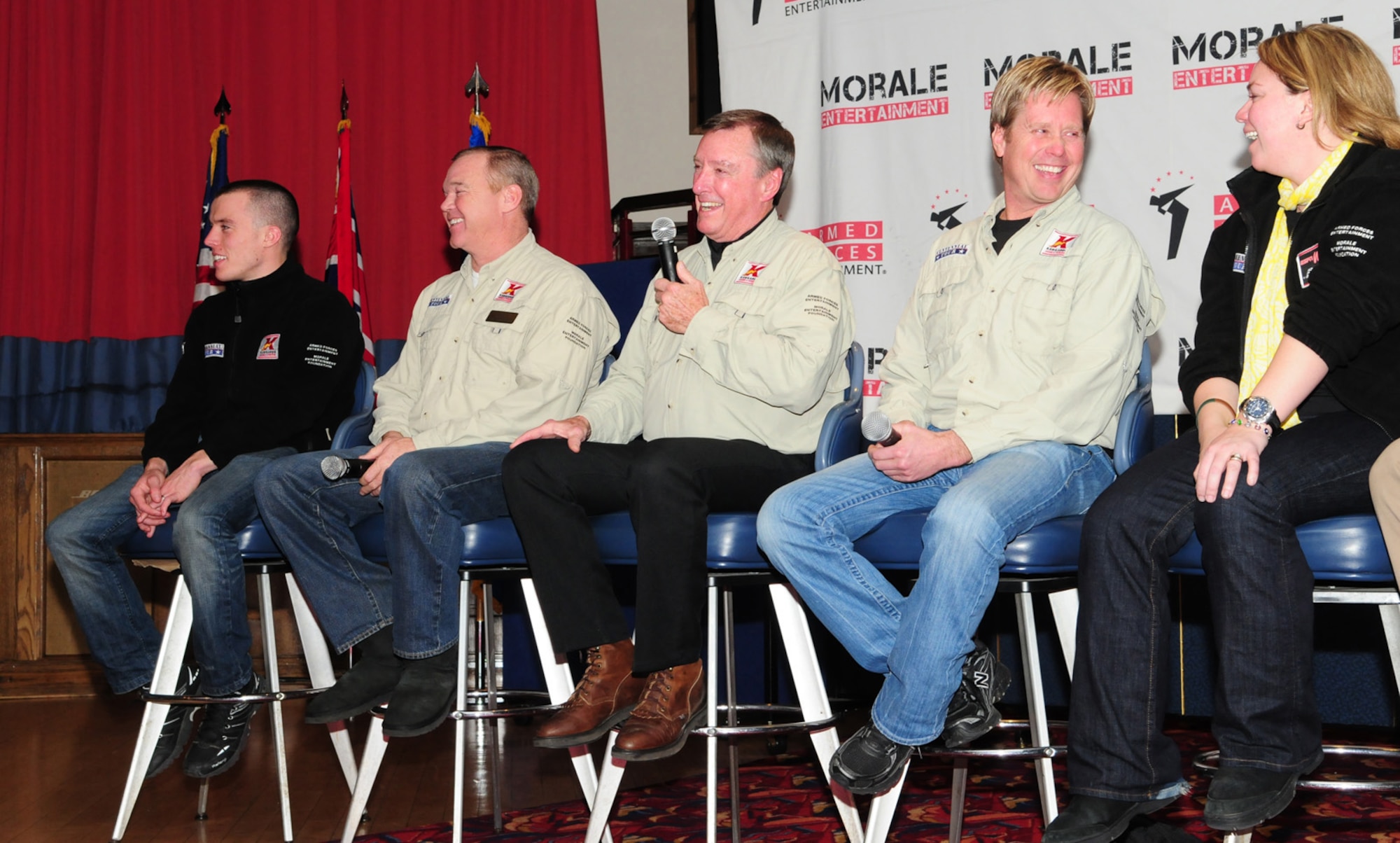 RAF MILDENHALL, England – Martin Plowman, Al Unser Jr., Johnny Rutherford, Davey Hamilton and Sarah Fisher talk to the audience at the Galaxy Club here Jan. 21, 2011, as part of the Indy 500 Centennial Tour. The drivers were on a morale visit to military troops around the world. While here, a few base personnel from RAFs Mildenhall and Lakenheath, got to ride in a two-seater IndyCar for a quick trip down the flightline. (U.S. Air Force photo/Karen Abeyasekere)