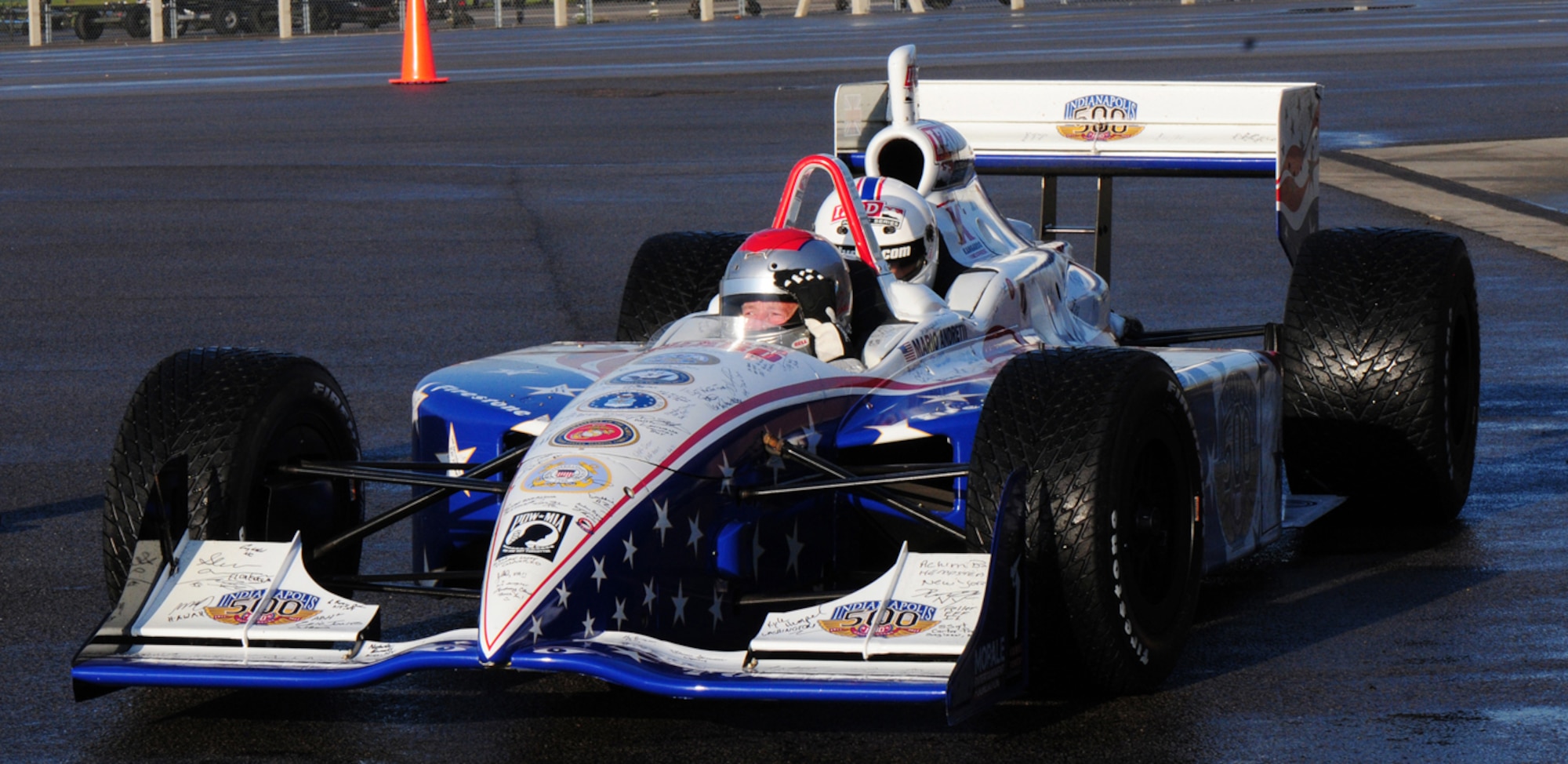 RAF MILDENHALL, England – Mario Andretti, former world champion Formula 1 and IndyCar racer, takes a Team Mildenhall member for a quick spin around the flightline here Jan. 21, 2011. Mr. Andretti joined several other drivers, past and present, on the Indy 500 Centennial Tour. The 10-day tour was to increase the morale of military troops around the world, and the drivers – Andretti, Al Unser Jr., Johnny Rutherford, Davey Hamilton, Larry Foyt and Martin Plowman, along with racing announcer Jack Arute and IZOD IndyCar Series spokesmodel Cameron Haven – visited more than 10,000 troops at military bases around the world. (U.S. Air Force photo/Karen Abeyasekere)