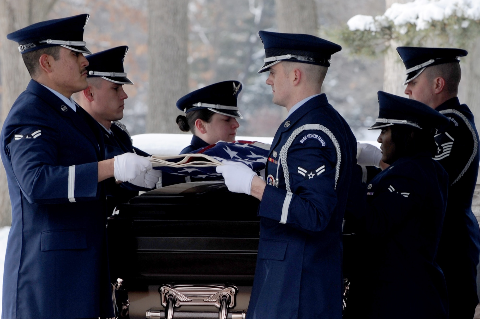 A 375th Air Mobility Wing Honor Guard detail ceremoniously folds a flag that was draped over a casket, Jan. 21, 2010 at the Jefferson Barracks National Cemetery, Mo. The Scott Honor Guard performs numerous details for veterans at this cemetery as well as covering funerals throughout a four state region. Airmen of all ranks and units are assigned to the Honor Guard for four months at a time. (U.S. Air Force photo/Staff Sgt. Brian J. Valencia)