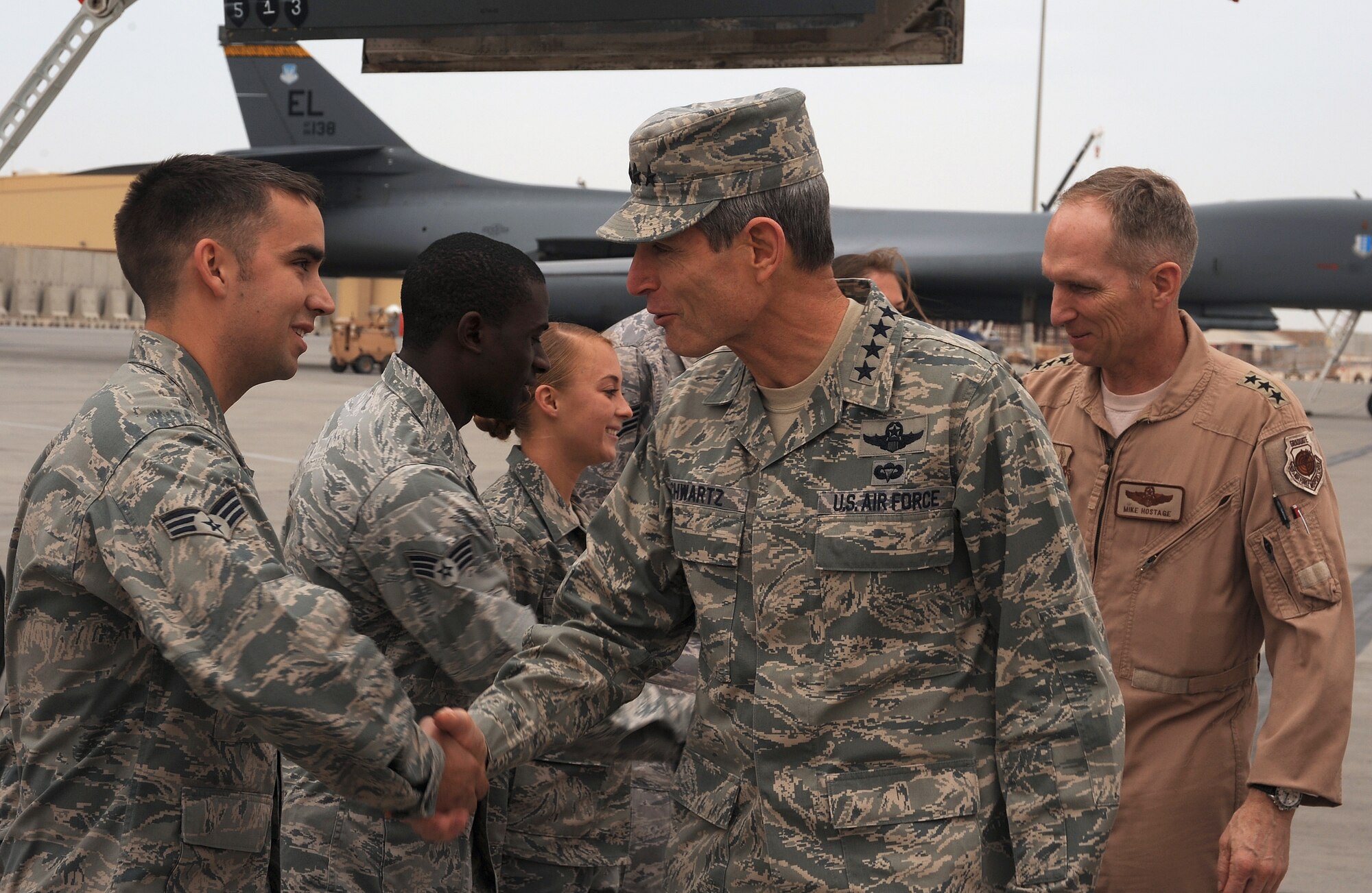 Senior Airman Mathew Boyd, 9th Expeditionary Aircraft Maintenance Unit, greets Air Force Chief of Staff Gen. Norton Schwartz and Lt. Gen. Mike Hostage, Commander for U.S. Central Command during his visit to Southwest Asia, Jan. 17. General Schwartz toured work areas, visited with Airmen around the base and addressed issues affecting the Air Force.  (U.S. Air Force photo/Staff Sergeant Liliana Moreno)