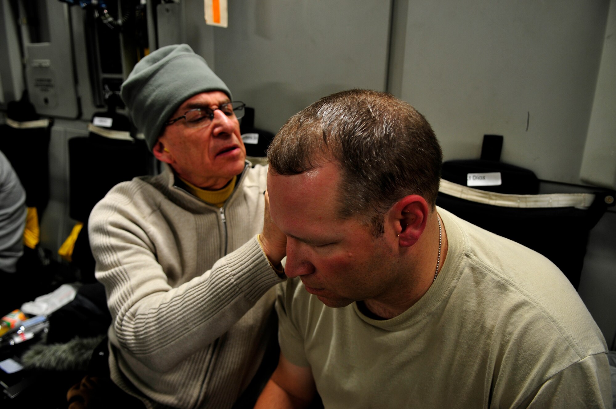 Dr. Niemtzow removes acupuncture needles from a U.S. Army soldier’s ears aboard an AE flight from Ramstein Air Base Germany to Joint Base Andrews, Md., Jan. 14, 2011. (U.S. Air Force photo by 2nd Lt. Christopher Diaz)