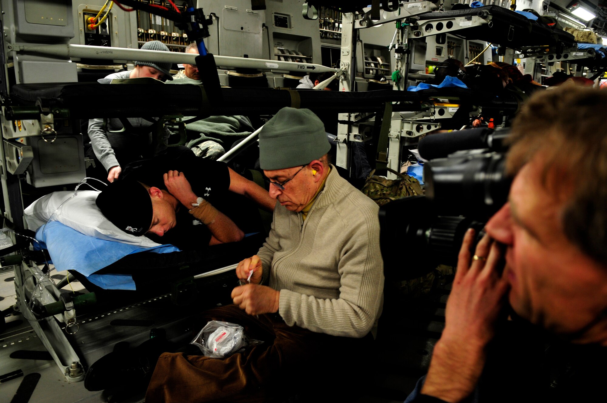 Dr. Niemtzow prepares to remove acupuncture needles from a U.S. Army soldier’s ears aboard an AE flight from Ramstein Air Base, Germany to Joint Base Andrews, Md., Jan. 14, 2011. (U.S. Air Force photo by 2nd Lt. Christopher Diaz)