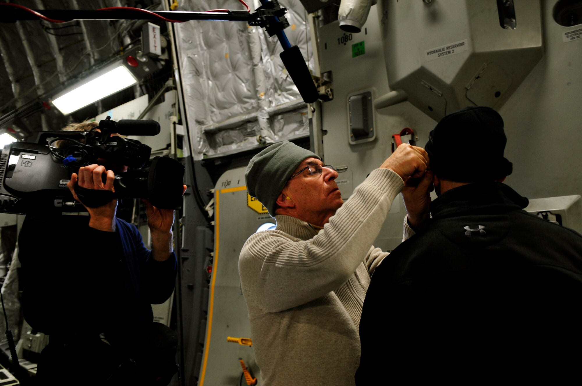 Retired Col. Dr. Richard Niemtzow, U.S. Air Force Surgeon General chief acupuncture consultant, removes acupuncture needles from a U.S. Army soldier’s ears aboard an aeromedical evacuation flight from Ramstein Air Base, Germany to Joint Base Andrews, Md. as part of a research study, Jan.14, 2011. The study aims to determine if acupuncture to the ear is an effective alternative treatment for pain reduction among wounded servicemembers. A film crew accompanied Dr. Niemtzow to produce a documentary on health care and alternative medicine. (U.S. Air Force photo by 2nd Lt. Christopher Diaz)