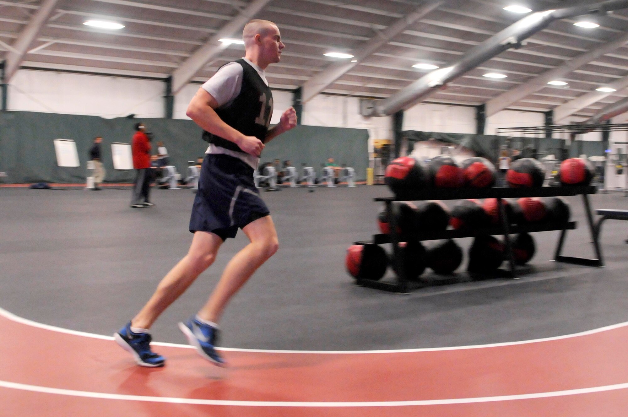 AIR FORCE DISTRICT OF WASHINGTON -- Airman 1st Class Daniel Bennet, U.S. Air Force Honor Guard color guard member, takes a turn during the running portion of a physical training test Jan. 18 at Joint Base Andrews. Like all Airmen, the AF Honor Guard members have to keep in shape to meet physical standards to include a 1.5 mile run, sit-ups, push-ups and a waist measurement. (U.S. Air Force photo Senior Airman Steele C. G. Britton)