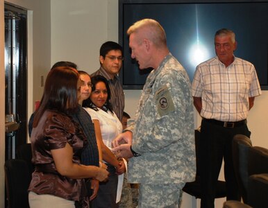 SOTO CANO AIR BASE, Honduras - Joint Task Force-Bravo commander Col. Gregory D. Reilly congratulates members of the 410th Regional Contracting Office here, Jan, 20, for being named "Office of the Year."  The office provides support in promoting peace, stability, and prosperity throughout Central America. (U.S Air Force photo/Capt. John Stamm)