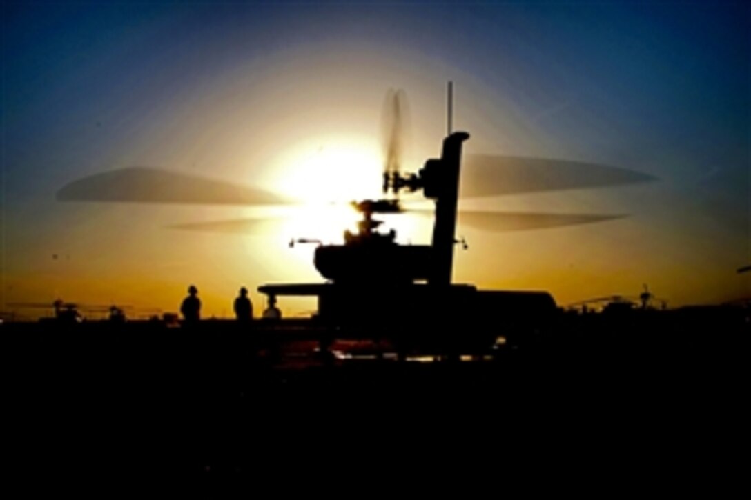 U.S. Army pilots and crew chiefs perform maintenance checks on an AH-64 Apache helicopter
as the sun sets on Kandahar Airfield, Afghanistan, Jan 18, 2010. The soldiers are assigned to 
101st Airborne Division's 101st Combat Aviation Brigade, based on Fort Campbell, Ky.