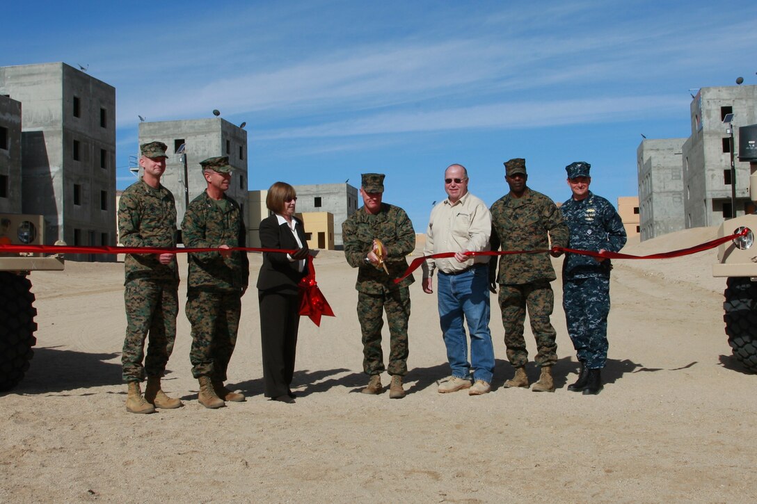 Brigadier Gen. H. Stacy Clardy III, commanding general, Marine Corps Air Ground Combat Center, cuts the ribbon to officially open the 274-acre Combined Arms Military Operations on Urban Terrain range complex Jan. 25, 2011. Clardy is joined (from left) by Col. Michael J. Bergerud, Chief of Staff, Marine Corps Systems Command, Quantico, Va., Col. David Smith, program manager, Training Systems, Marine Corps Systems Command, Quantico, Susan Horsefall, contractor from Allied Container Systems, Joe Whipple, contractor from SOTEK Pacific, SgtMaj. Harrison L. Tanksley, sergeant major, MCAGCC, and Navy Capt. Marko Medved, operations officer, Facilities Engineering Command Southwest, San Diego. The facility is the Corps newest and largest range of its kind.