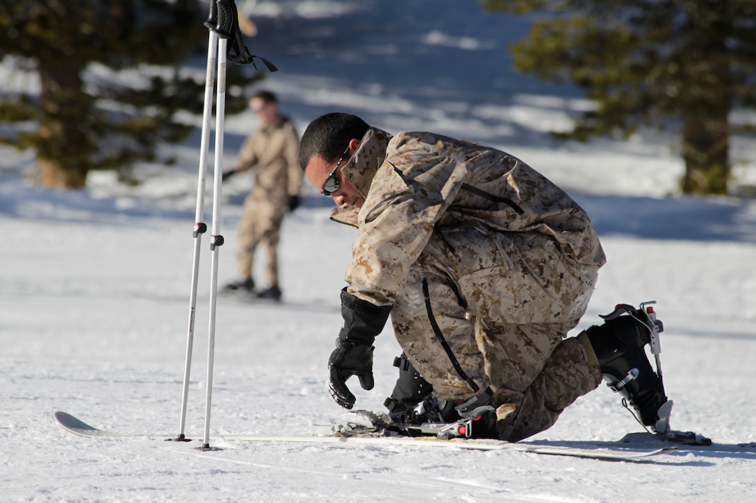 A Marine bends down to fix his ski Jan. 25, 2011,at the Marine Corps Mountain Warfare Training Center, Bridgeport, Calif.