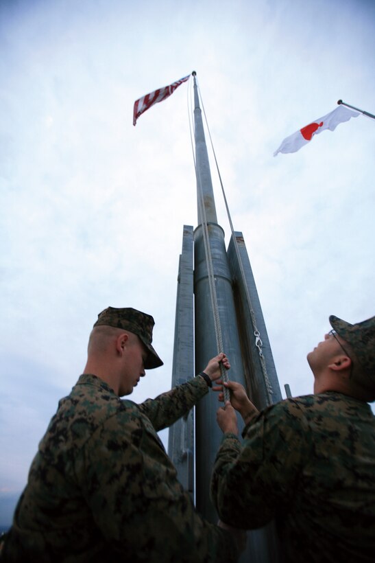 The national colors wave in the breeze as twilight approaches, shortly before the evening colors ceremony outside of Building 1 on Camp Butler.