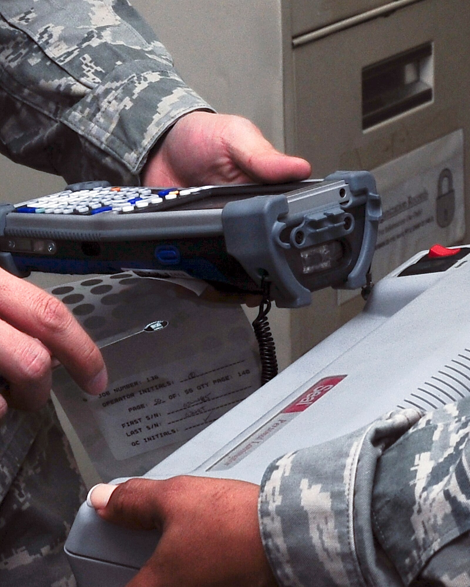 YOKOTA AIR BASE, Japan -- Members of the 374th Logistics Readiness Squadron equipment accountability element, use the new asset marking and tracking system to label a shredder here Jan. 25. The AMT system is being implemented Air Force wide. (U.S. Air Force Photo/Airman 1st Class Krystal Garrett)