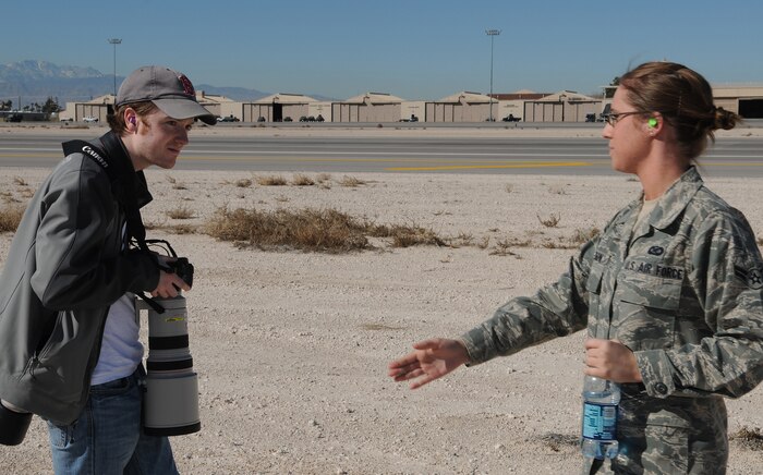 NELLIS AIR FORCE BASE, Nev. -- Airman 1st Class Whitney Jackson, 99th Air Base Wing Public Affairs journalist, guides Jeremy Dwyer-Lindgren away from the flight line during an organized media day for Red Flag 11-2 Jan. 25. The 99th ABW Public Affairs office escorted more than 40 aviation photographers from across North America and Europe to take photos of aircraft for various publications. Throughout the combined, combat training exercise the office will arrange about 13 media visits for local and national news agencies to tell the Red Flag story. (U.S. Air Force photo/Staff Sgt. Benjamin Wilson)