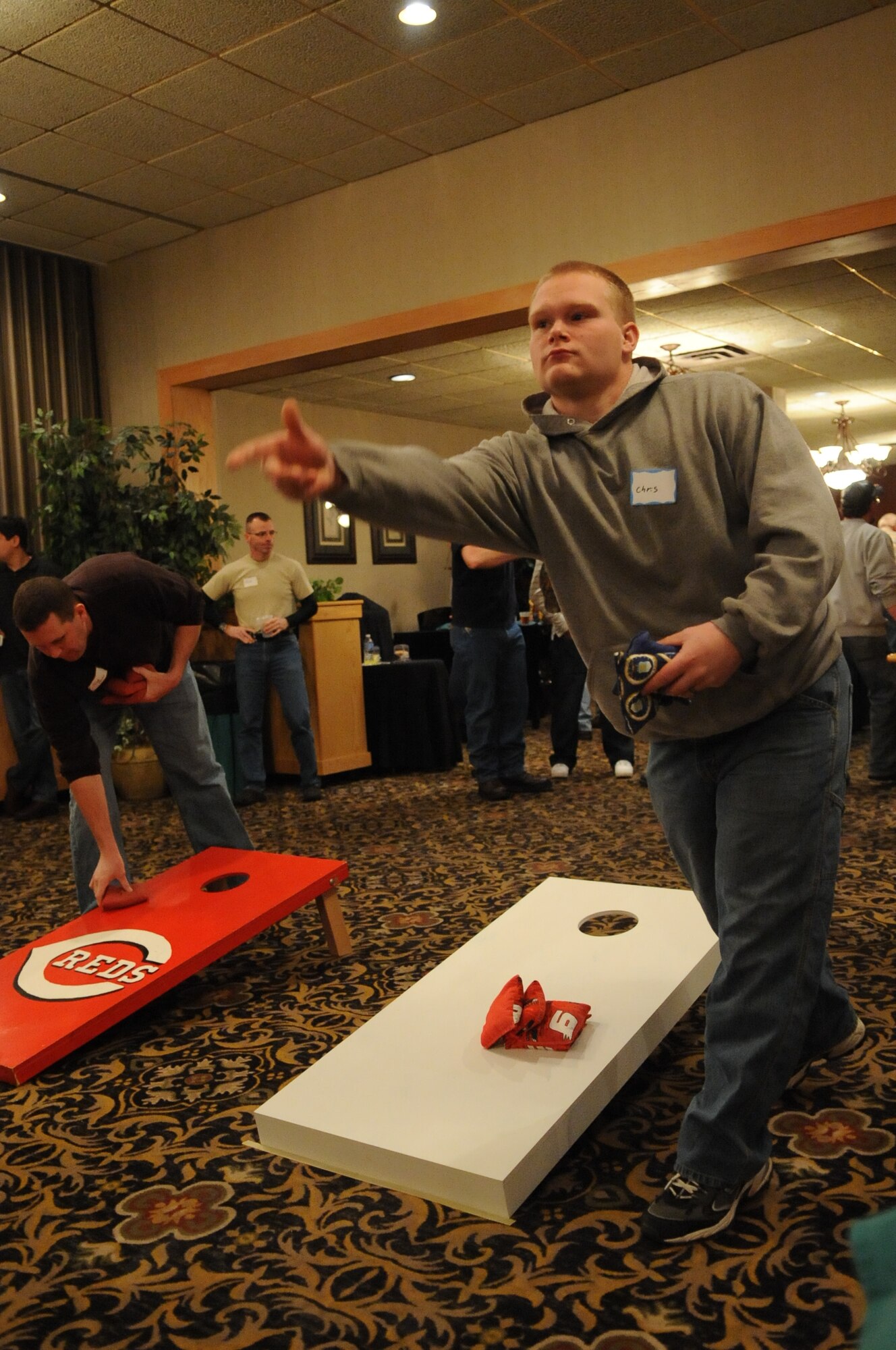MINOT AIR FORCE BASE, N.D. – Airman 1st Class Chris Buchfink, an aircraft structural maintenance technician with the 5th Maintenance Squadron, tosses a bean bag during a game of corn hole at the 46th Annual Team Minot Sportsmen Feed held at the Jimmy Doolittle Center here Jan. 23. The annual event brings Minot’s Airmen and members of the local community together for food, fun and camaraderie. (U.S. Air Force photo/Tech. Sgt. Thomas Dow)