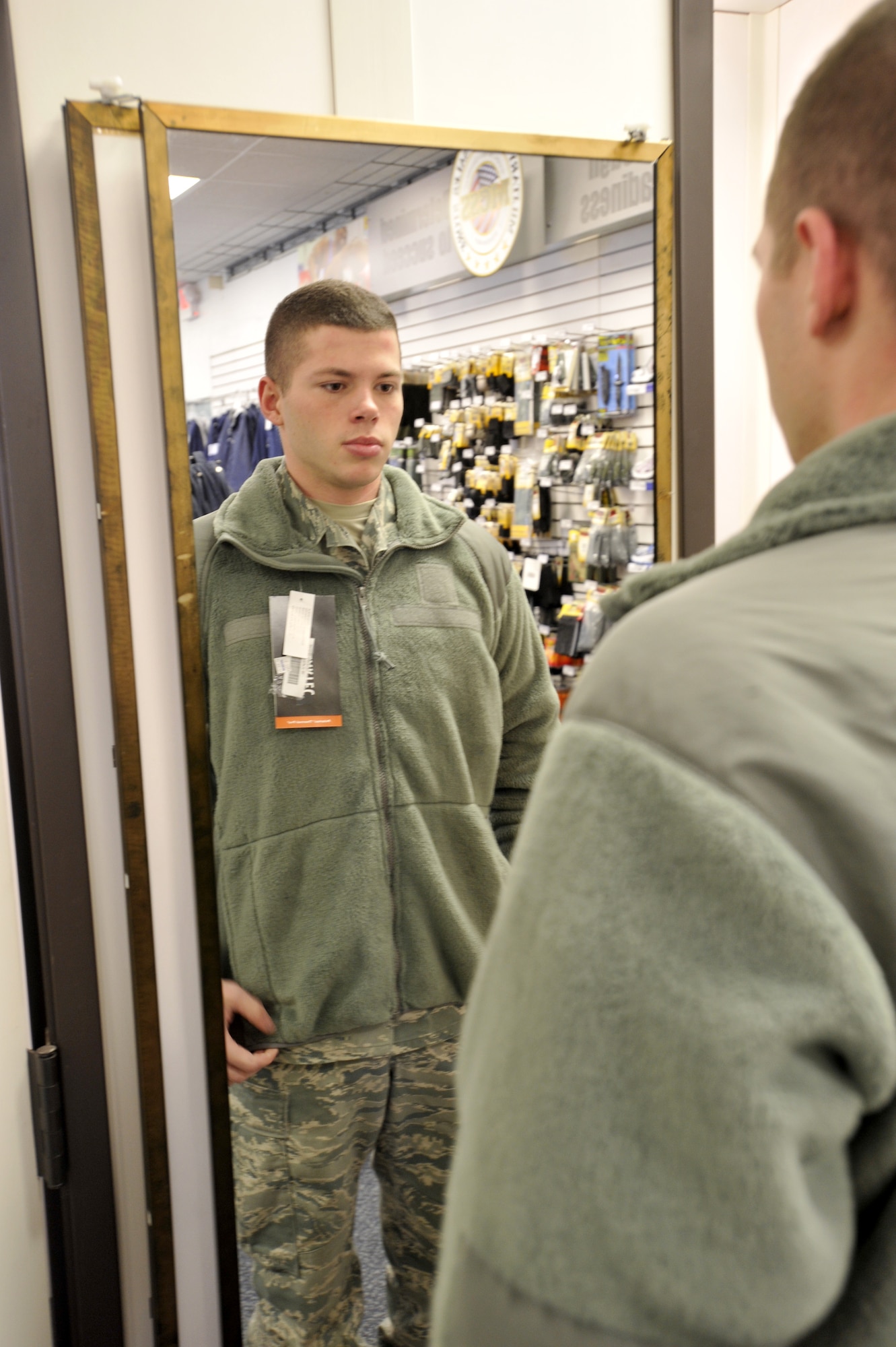Senior Airman Lon Fluman of the 712th Aircraft Maintenance Squadron tries on a fleece jacket at the Military Clothing Sales Store on Dover Air Force Base, Del., Jan. 25, 2011. Fleece jackets and other cold-weather gear are popular items at clothing sales due to the recent cold weather. (U.S. Air Force photo by Tech. Sgt. Chuck Walker/Released)