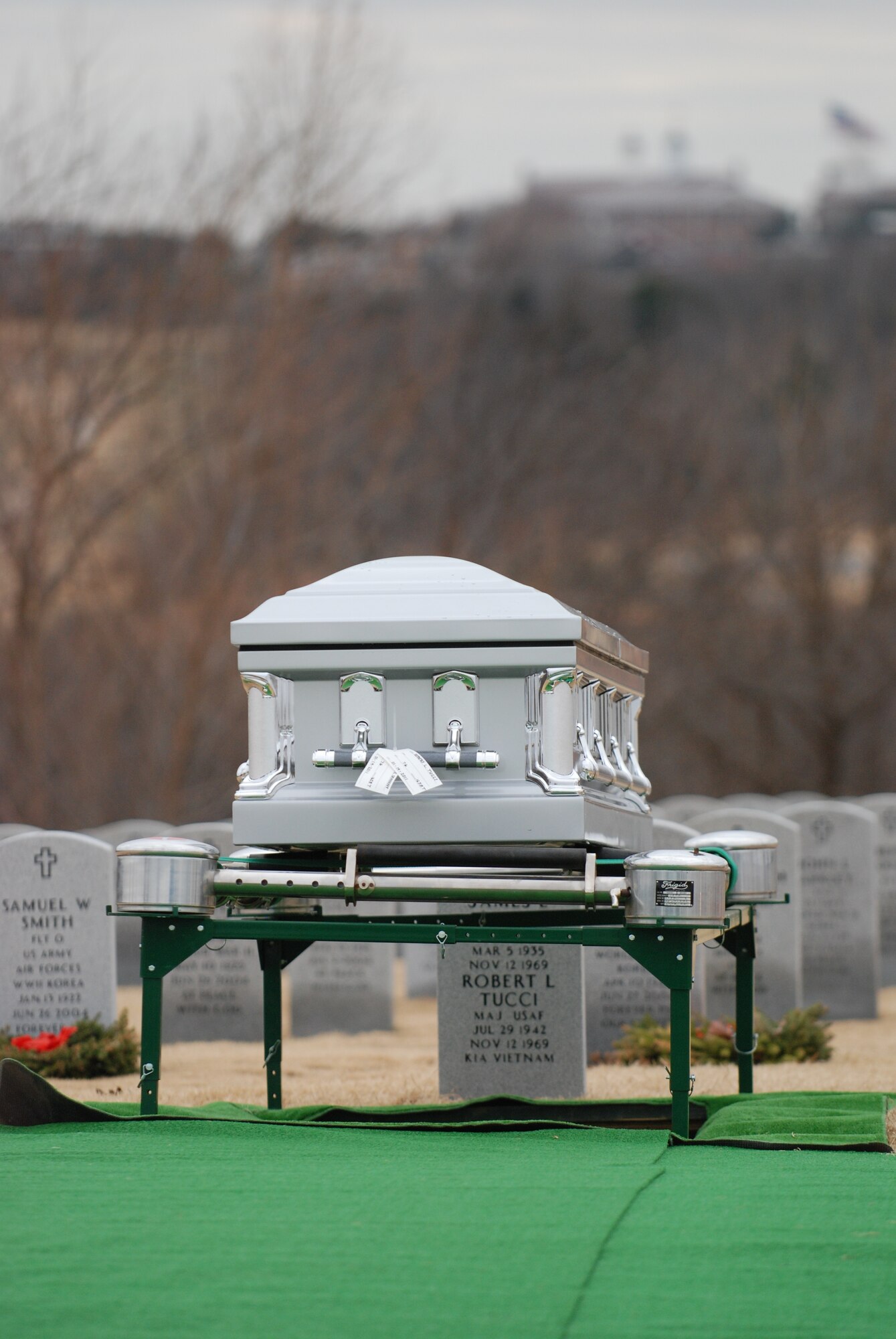 DALLAS— A casket is prepared to be lowered into a grave site Jan. 14 during a funeral ceremony at the Dallas-Fort Worth National Cemetery. More than 41 years ago, Col. James Dennany, 34, of Kalamazoo, Mich., and Maj. Robert Tucci, 27, of Detroit, were flying an F-4D escorting an AC-130 gunship on a night strike mission during the Vietnam War, when they were shot down by anti-aircraft gunfire. A search was conducted afterward, but revealed nothing. No other search was initiated due to heavy anti-aircraft fire in the area. In 1999, officials in Laos turned over crew-related equipment, two .38 caliber pistols and human remains. Scientists from the Joint POW/MIA Accounting Command used circumstantial evidence and forensic tools to identify the remains. Col. Dennany and Maj. Tucci were laid to rest Jan. 14 at the Dallas-Fort Worth National Cemetery. According to the Defense Prisoner of War/Missing Personnel Office, there are still 1,713 U.S. servicemen still unaccounted for from the Vietnam War. (U.S Air Force photo/ Airman 1st Class Shannon Hall)