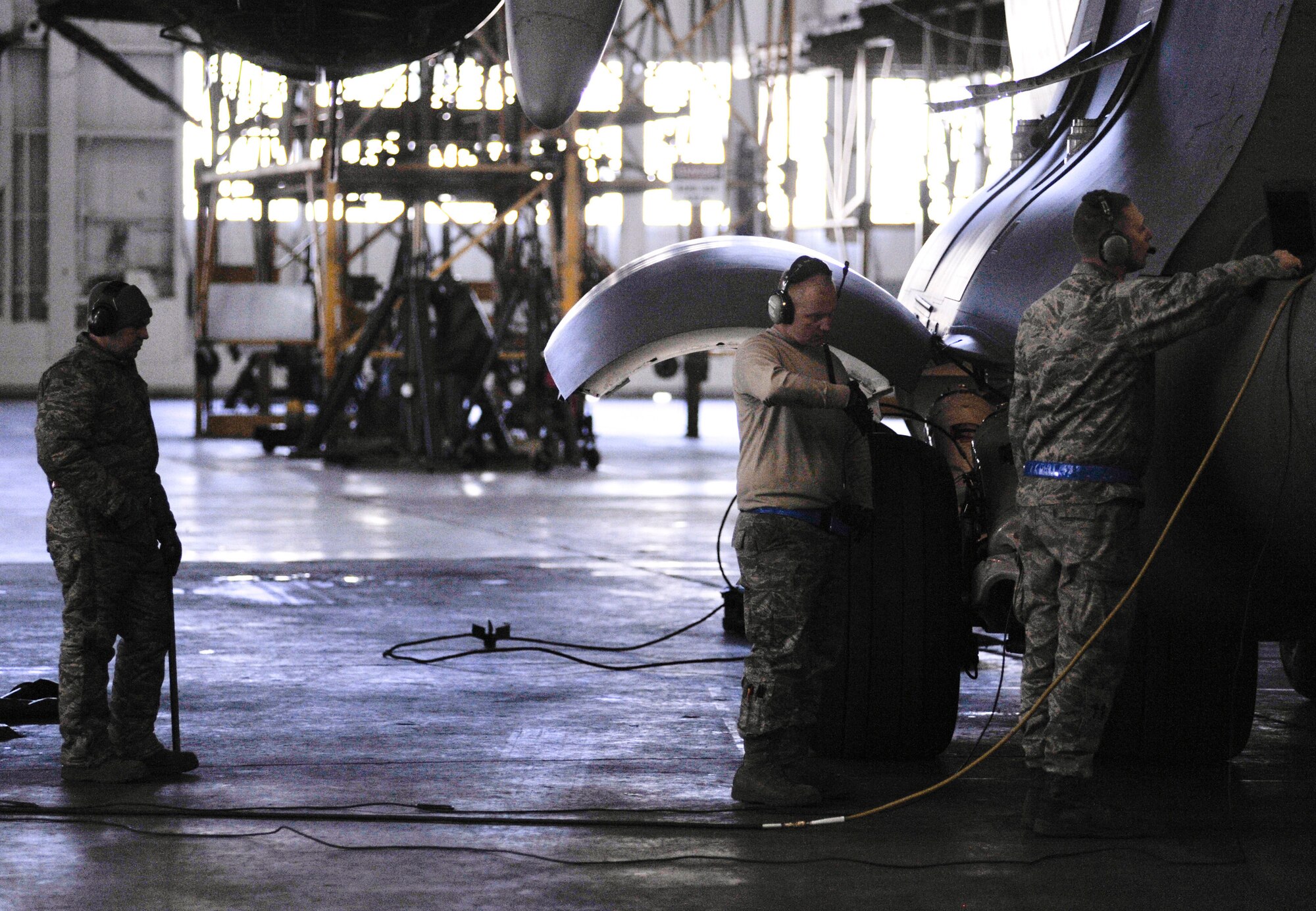 Airman 1st Class Michael Banks(left), C-17 Globemaster III crew chief, Staff Sgt. Chance Wisdom, integrated flight control systems specialist, and Staff Sgt. Travis Norris, C-17 crew chief, all with the 736th Aircraft Maintenance Squadron work together to replace the middle tire of the rear left main landing gear at Dover Air Force Base, Del., Jan. 24, 2011. The tire had a small tear and needed to be replaced. (U.S. Air Force photo/Airman 1st Class Jacob Morgan)