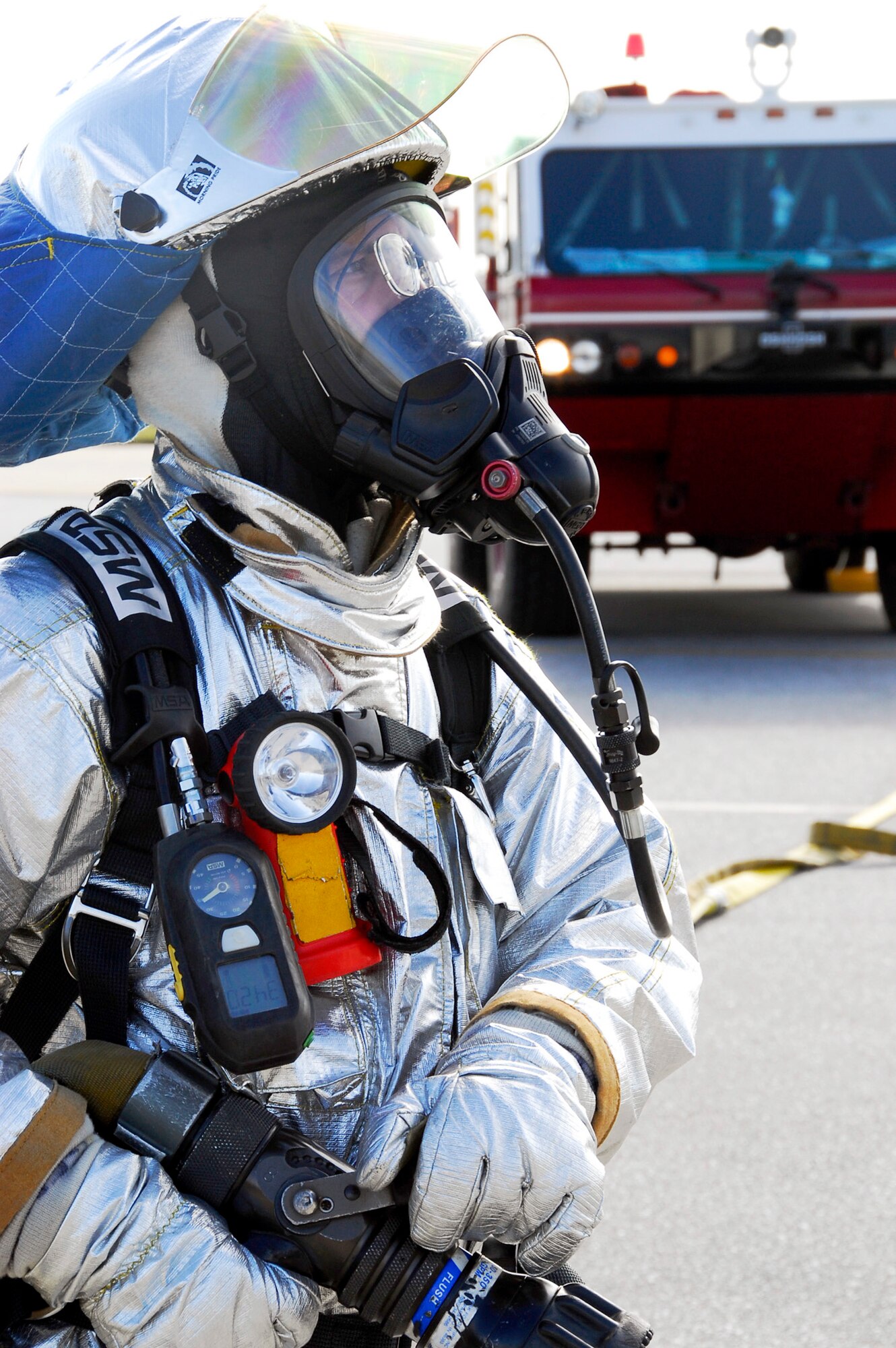 A firefighter from the 18th Civil Engineer Squadron stands ready with a fire hose for a simulated-burning-aircraft scenario during Beverly High 11-02, a Local Operational Readiness Exercise Jan. 19, 2011, at Kadena Air Base, Japan. The scenario tested the skills and capabilities of Kadena AB's emergency-response professionals. (U.S. Air Force photo/Airman 1st Class Maeson L. Elleman) 